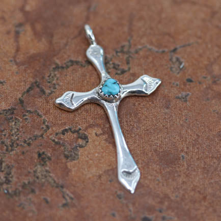 An authentic Navajo Native American Cross Pendant. It is made from Sterling Silver. It is about 2" in length including the bail, and about 1 1/8" in width.