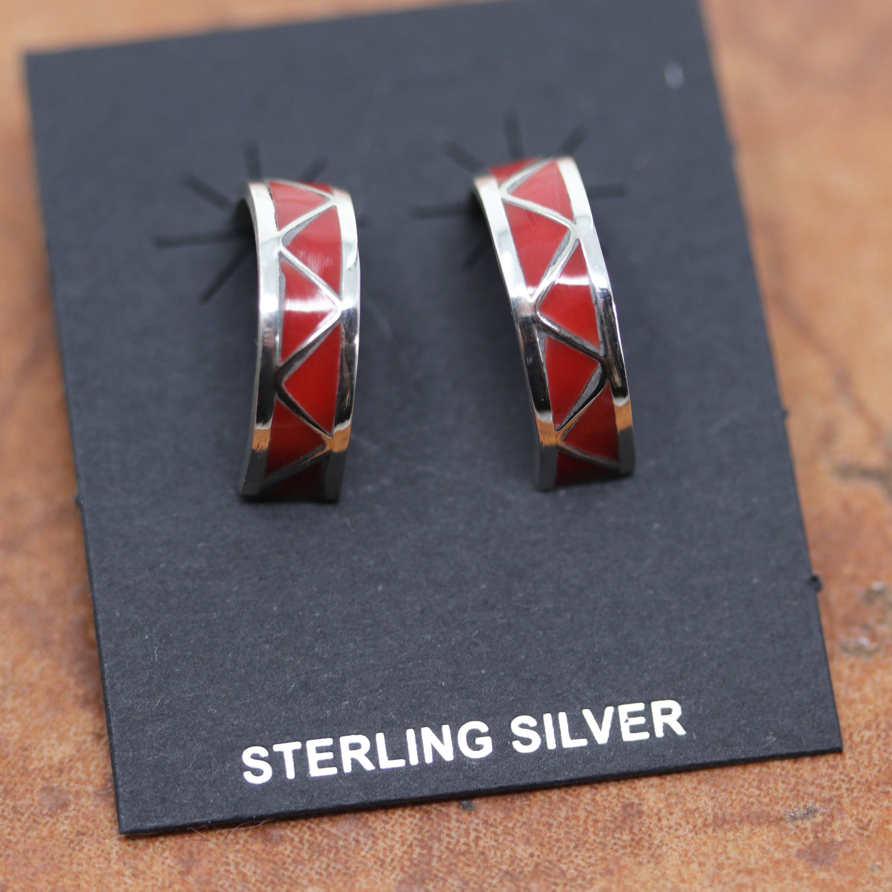 Beautiful Zuni Native American earrings. They are made from sterling silver and coral. Each earring is 1" in length, and about 1/4" in width.