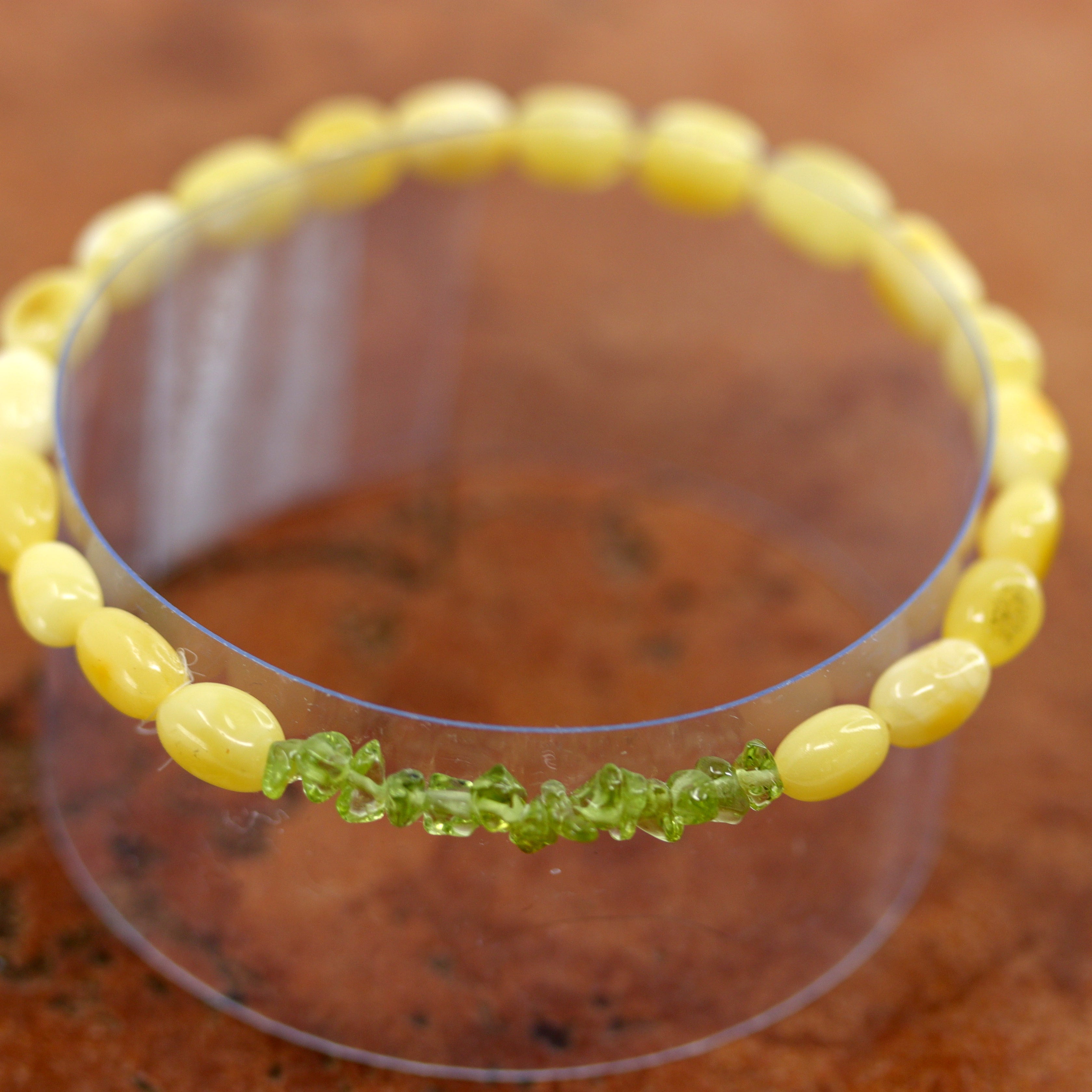 The amber comes from the Baltic Sea. It also has peridot nuggets. It fits sizes 6" (more loose) to about 7" (tighter fit). The width is 3/8".