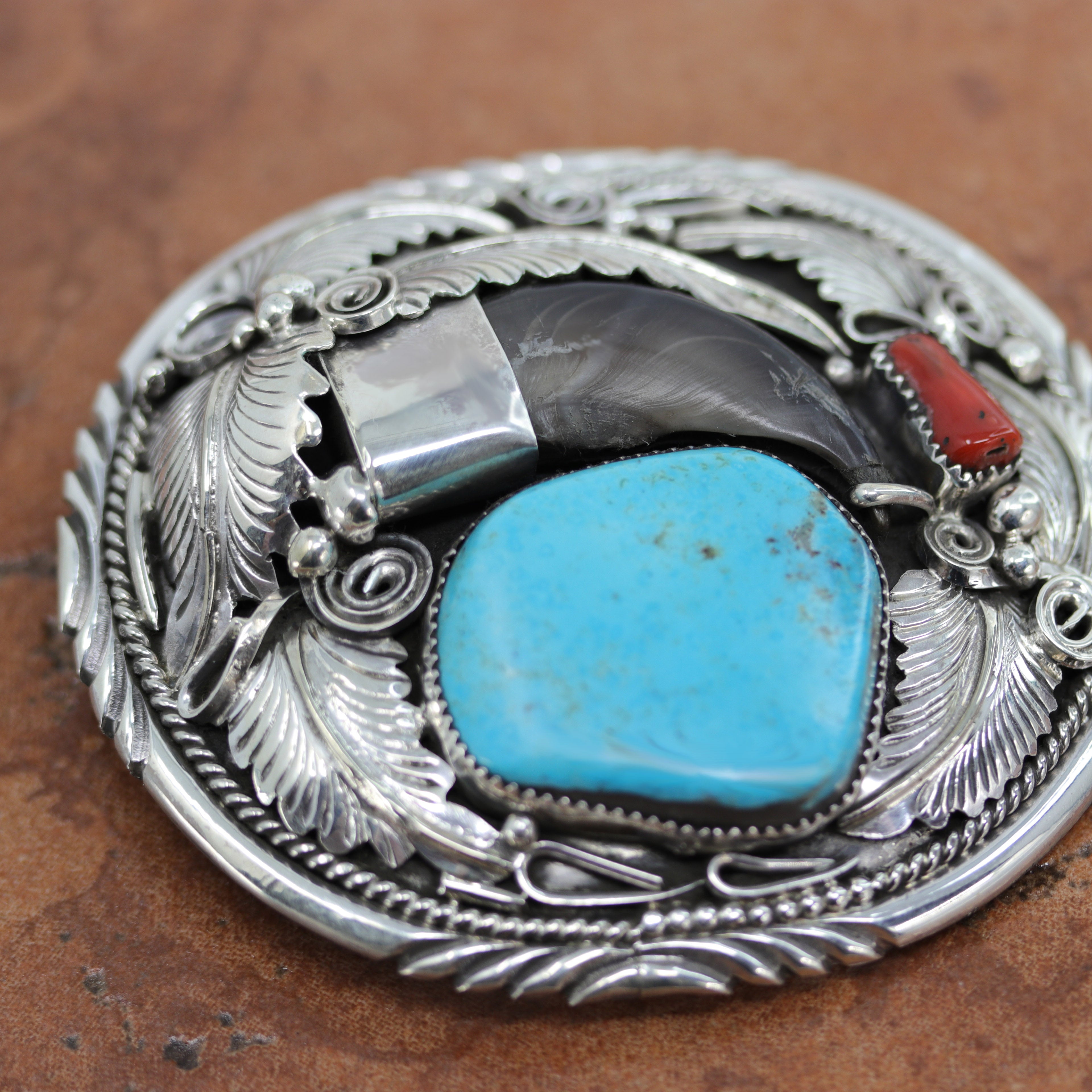 Gorgeous Navajo Native American Belt Buckle. It is made from sterling silver, coral, and turquoise. It is stamped Sterling and M Thomas Jr. It is 3" long, and 3 3/8" wide. It will hold a belt up to 1 1/2" wide.