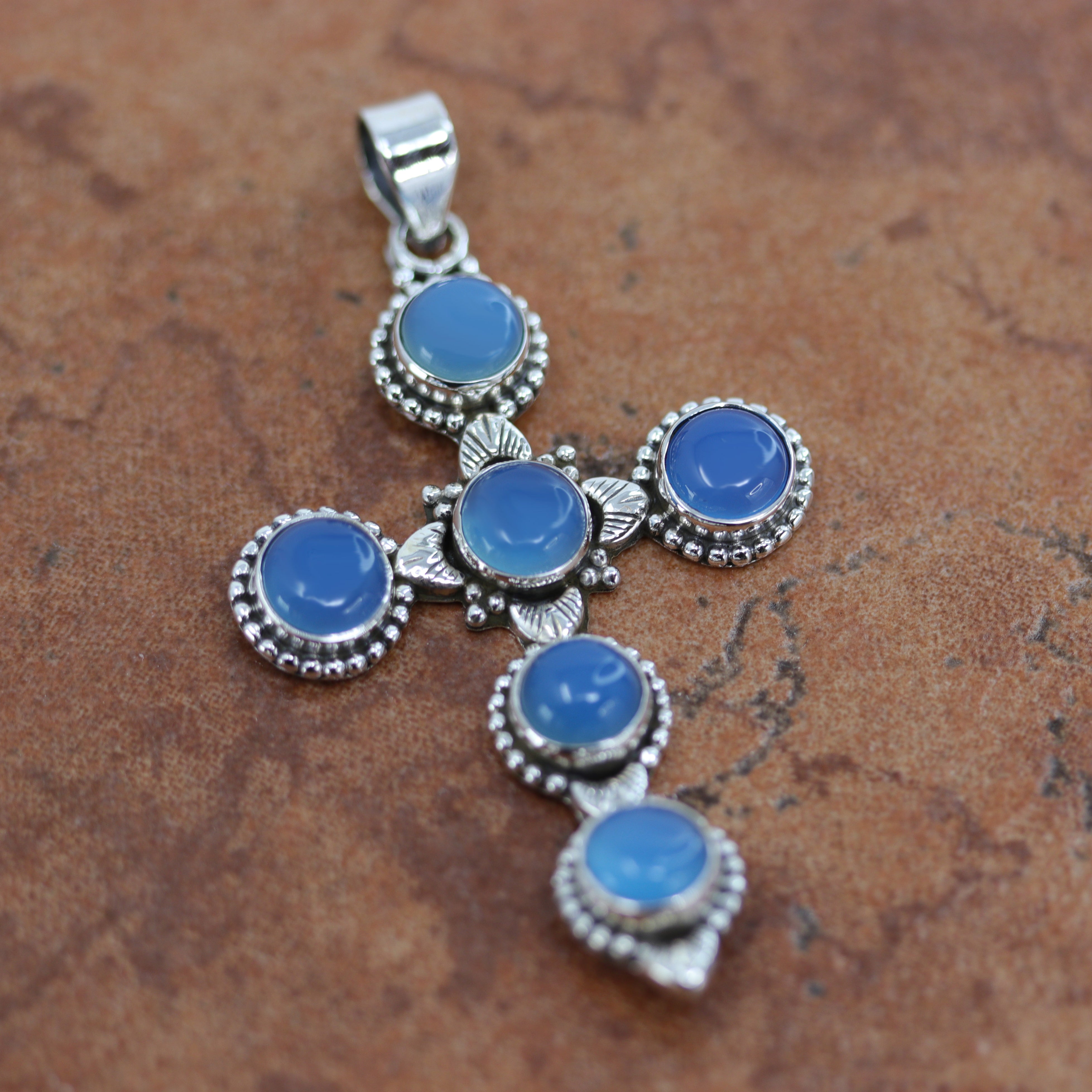 It is made from Sterling Silver and blue chalcedony. It is about 2 1/2" in length including the bail, and about 1 7/16" in width.