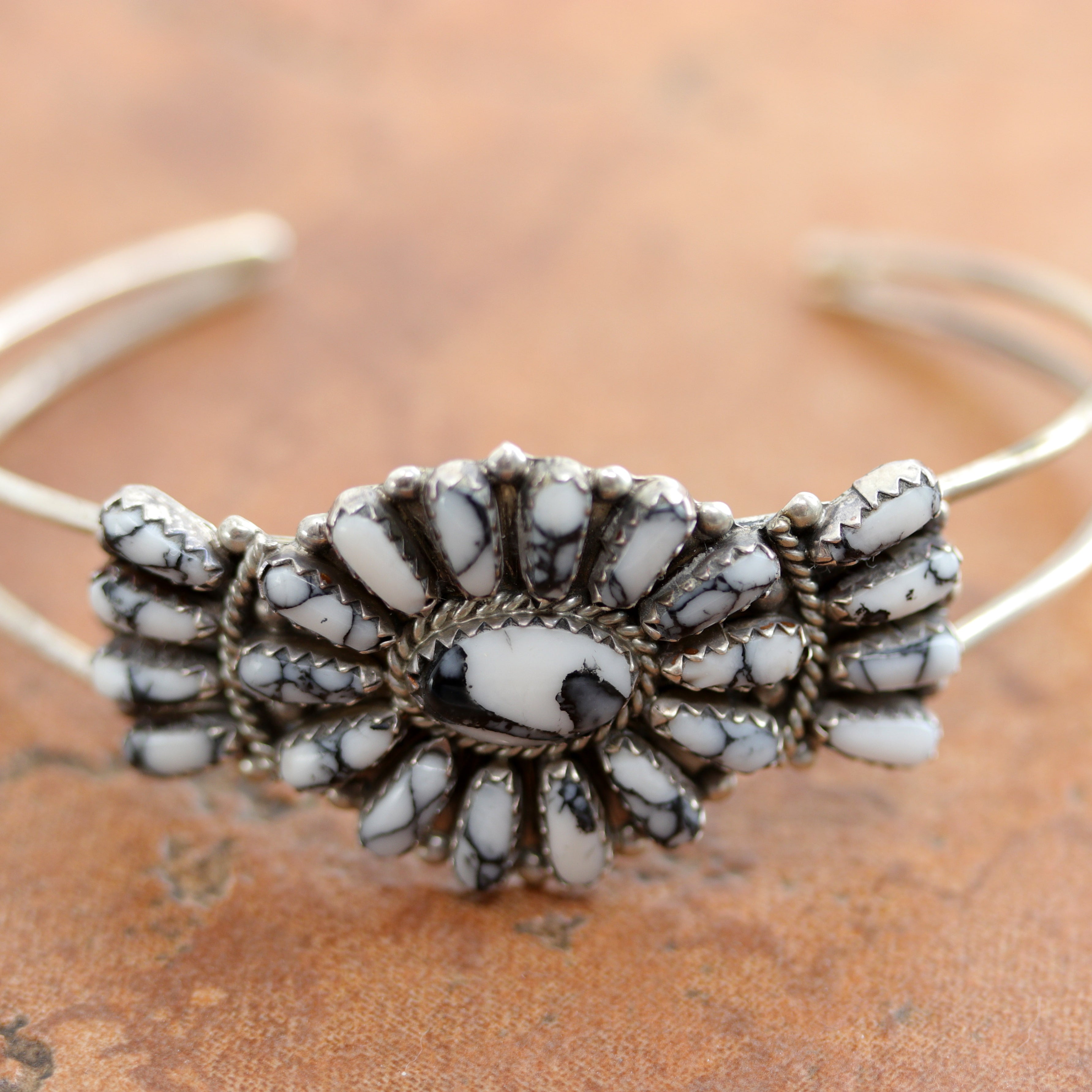 A very nice authentic white howlite Navajo Native American bracelet. It is made from sterling silver and man made howlite. It is about 5 1/2" around and about 1" wide. The opening is about 1 1/4", and partly flexible.