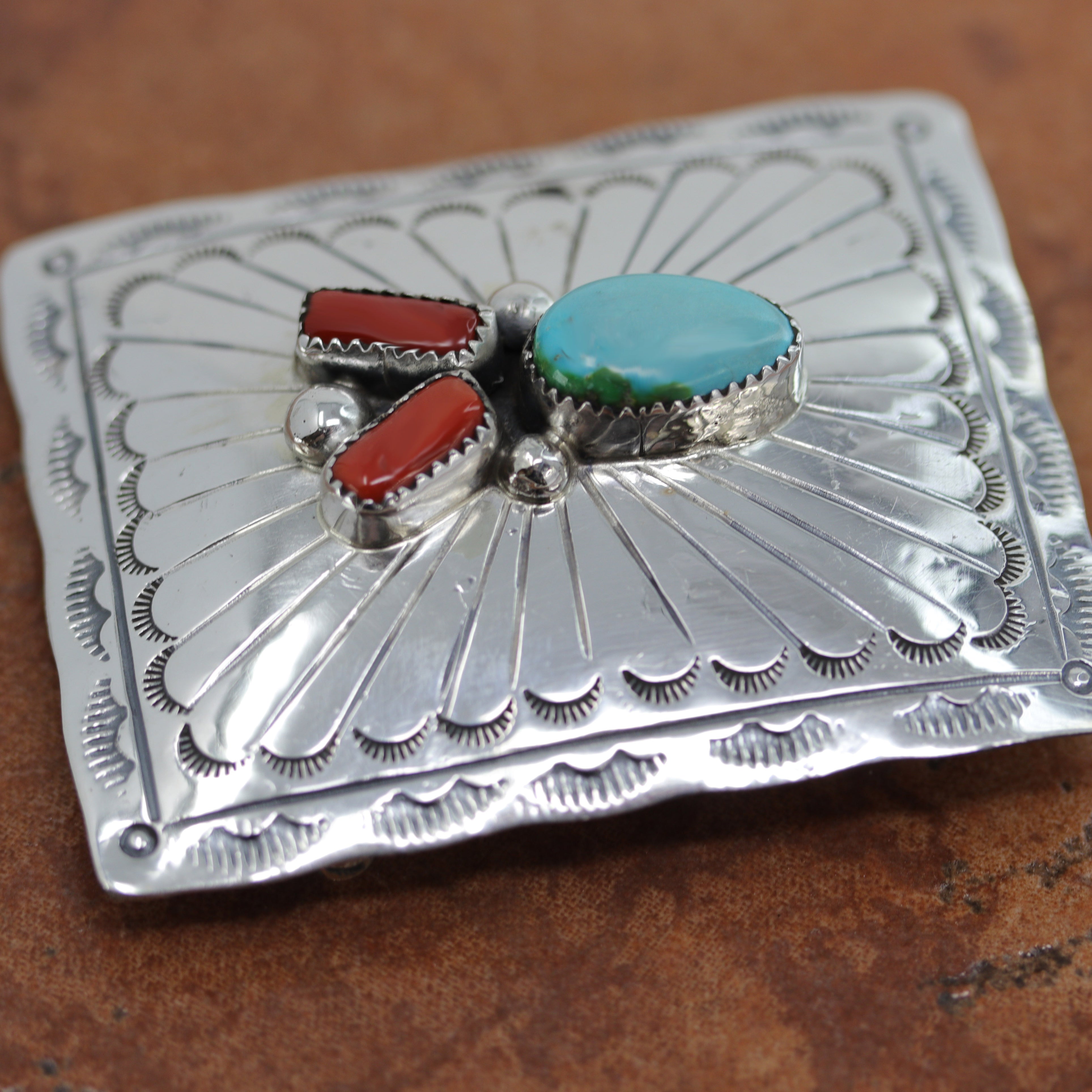 Authentic, Navajo Native American Belt Buckle. It is made from sterling silver, coral, and turquoise. It is stamped Sterling. It is 2 5/8" by 1 7/8". It will hold a belt up to 1 1/2" wide. 