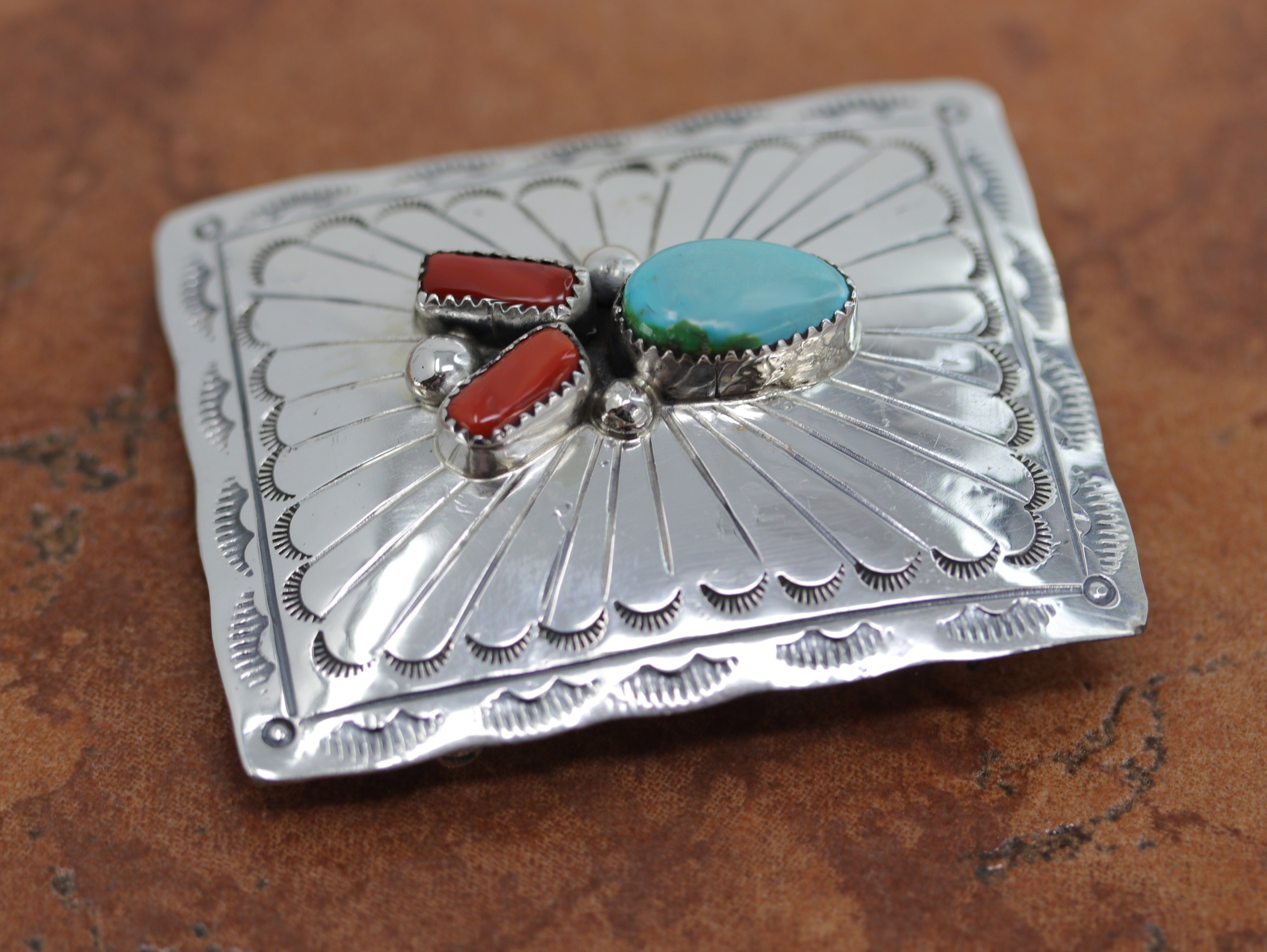 Authentic, Navajo Native American Belt Buckle. It is made from sterling silver, coral, and turquoise. It is stamped Sterling. It is 2 5/8" by 1 7/8". It will hold a belt up to 1 1/2" wide. 