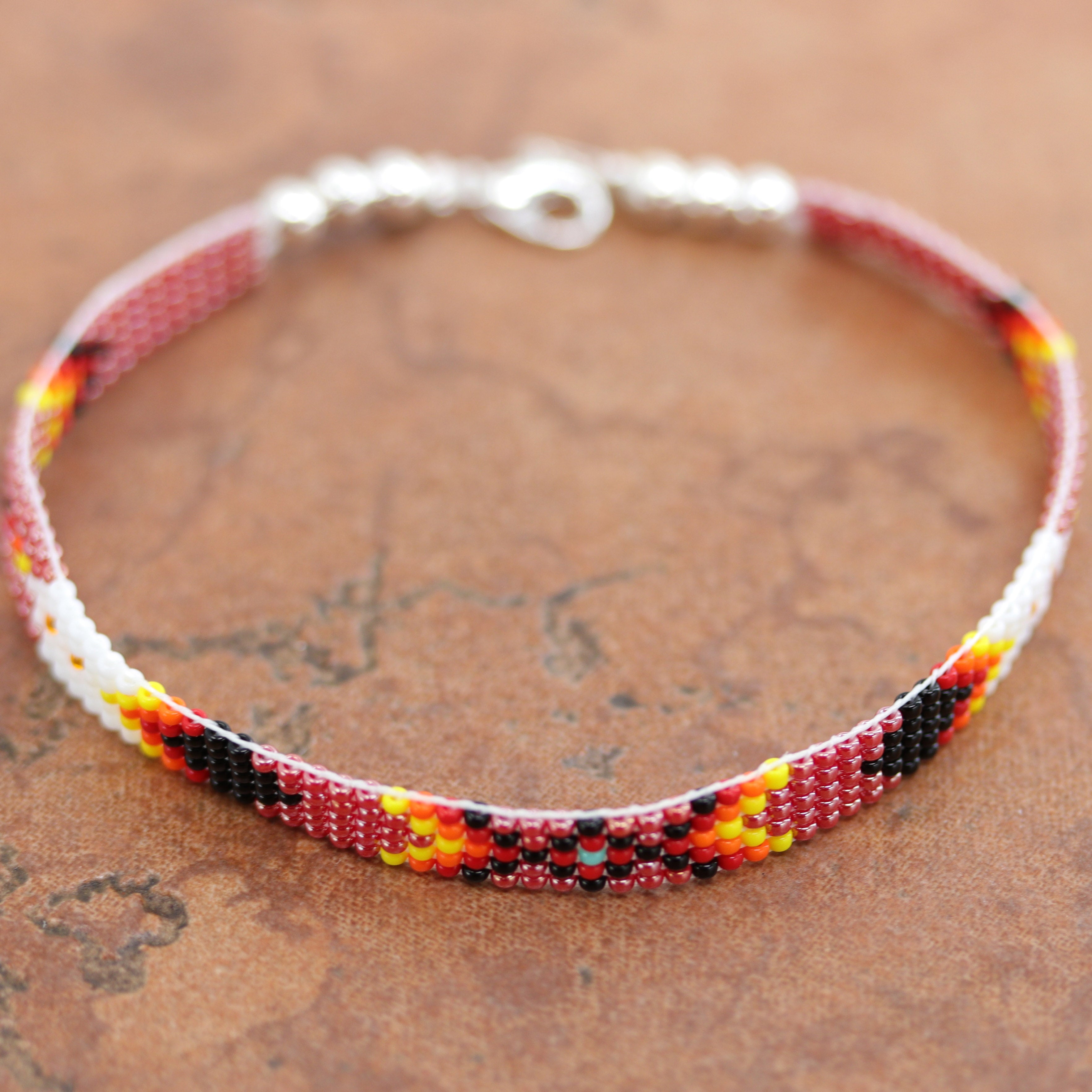 A beautiful Navajo red and white beaded bracelet. It is about 7 7/8" from end to end and the width is 1/4" at the widest point.