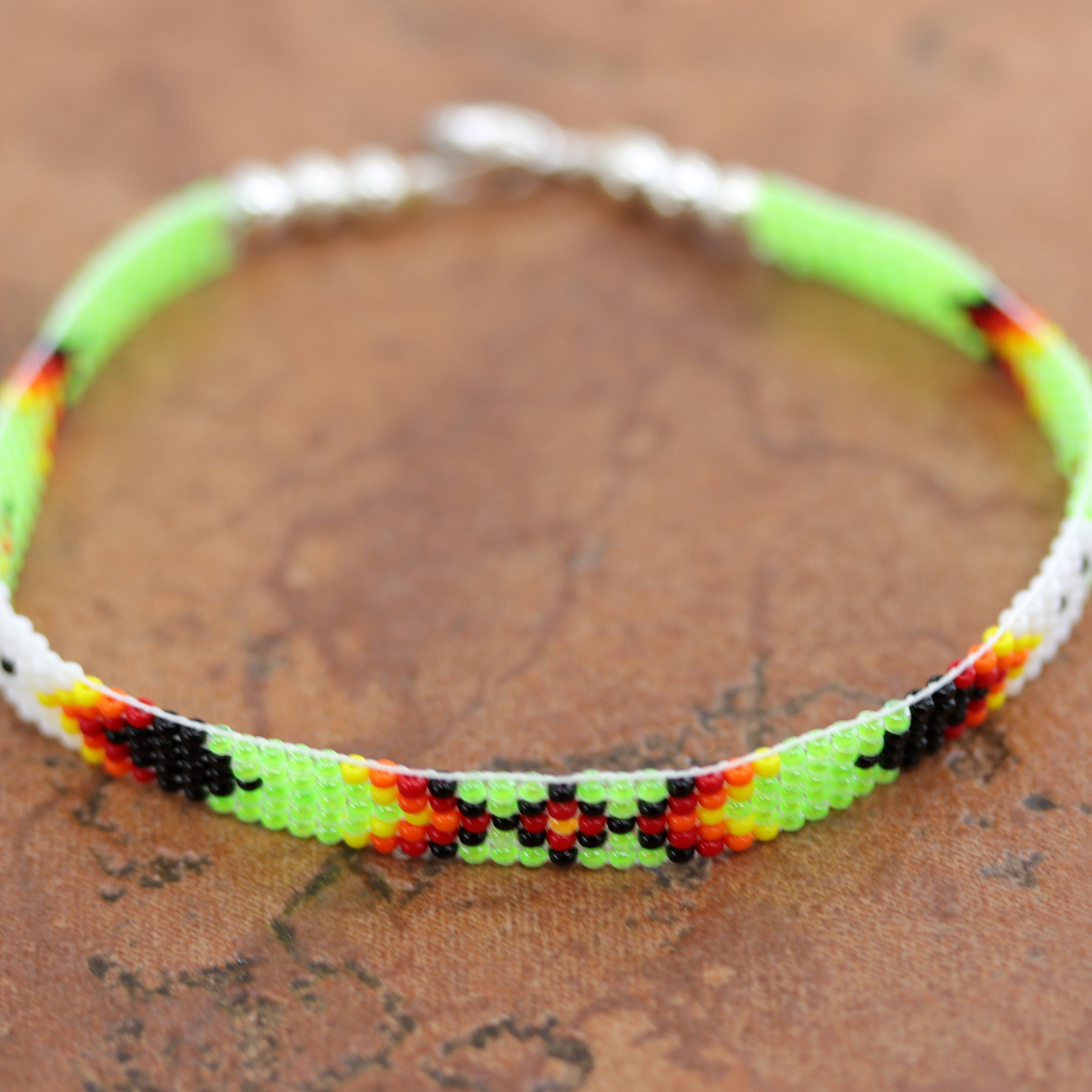 A beautiful Navajo green and white beaded bracelet. It is about 7 7/8" from end to end and the width is 1/4" at the widest point.