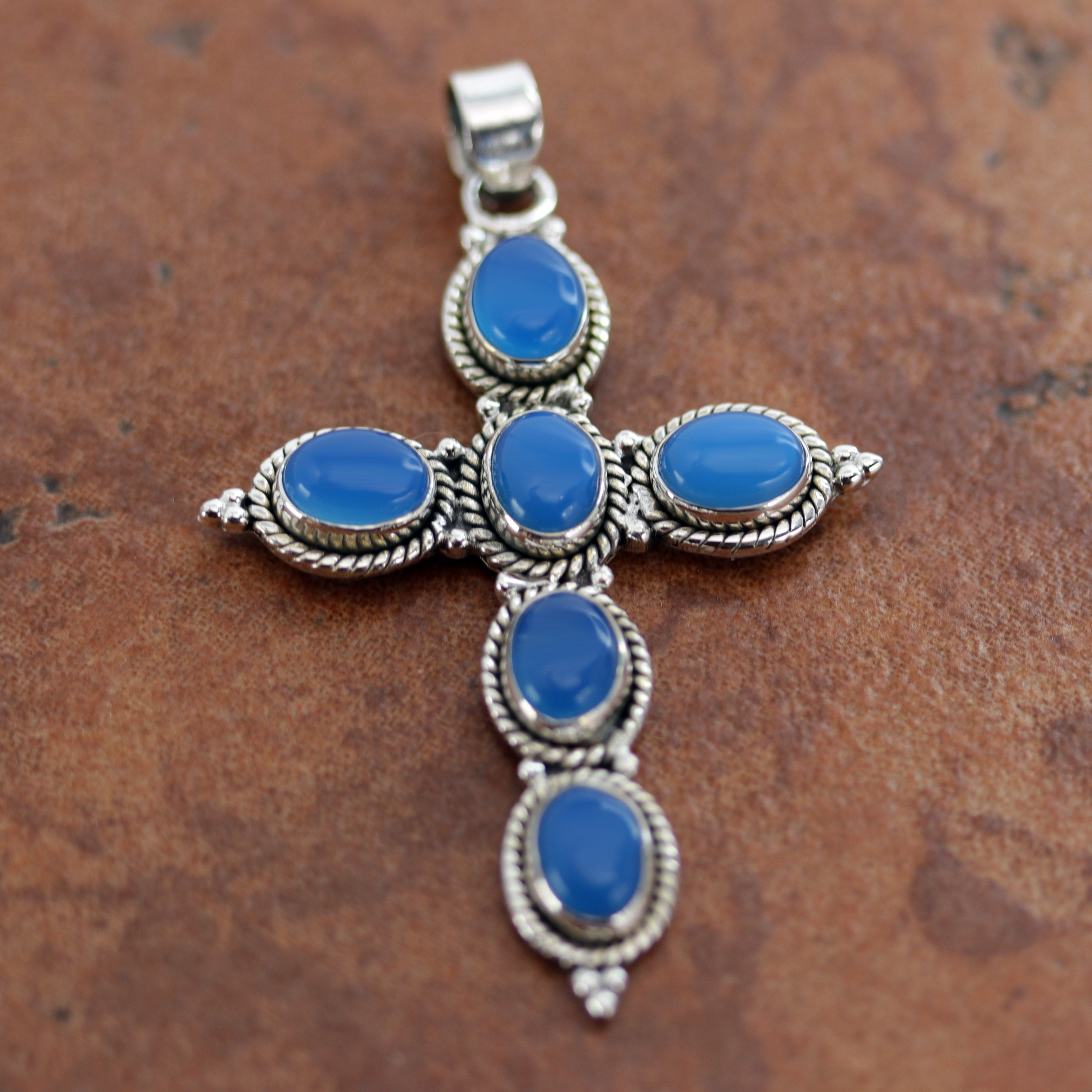 It is made from Sterling Silver and blue chalcedony. It is about 2 3/8" in length including the bail, and about 1 5/8" in width.