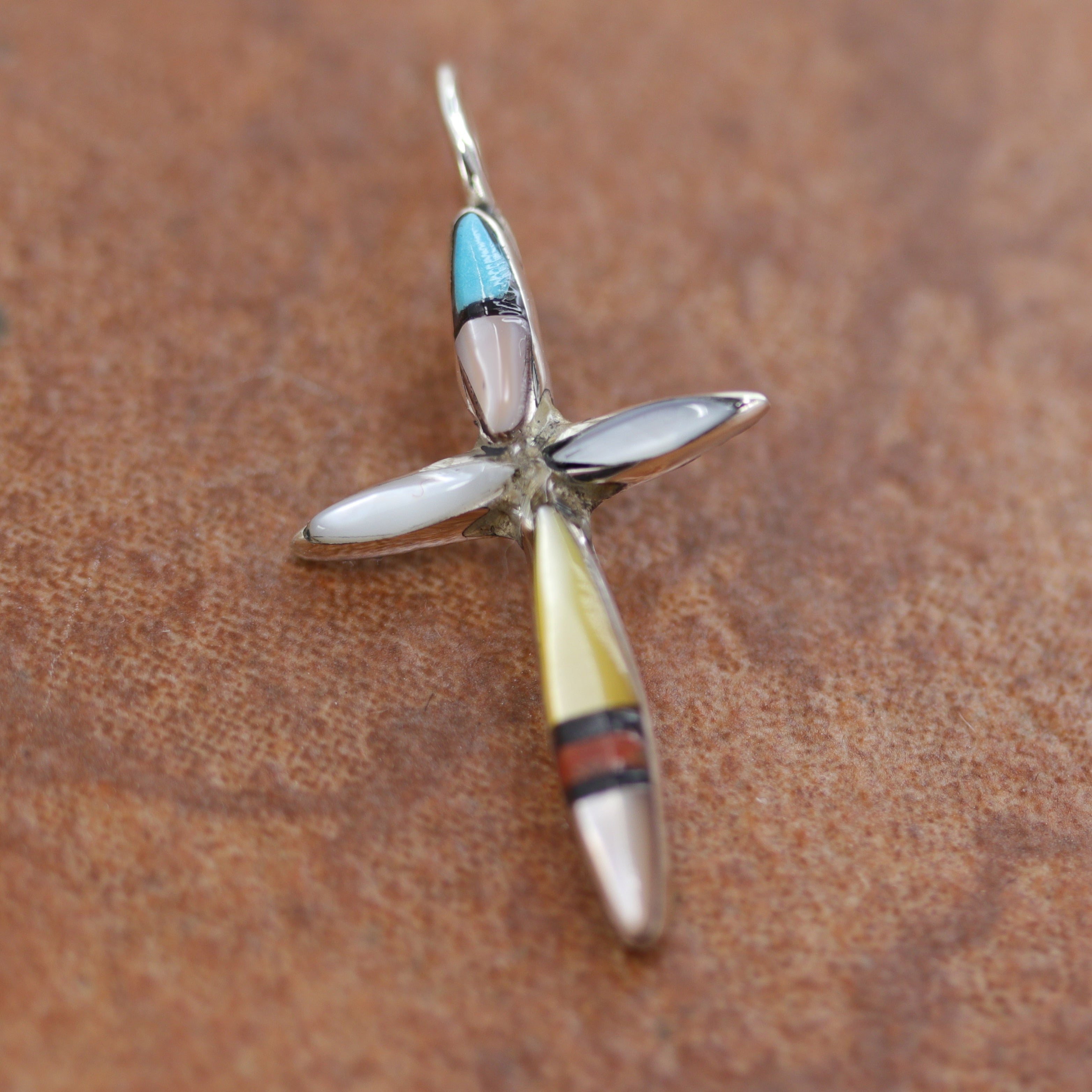An authentic Zuni Native American Pendant. It is made from Sterling Silver and gemstones. It is about 1 1/4" in length including the bail, and about 3/4" in width. 