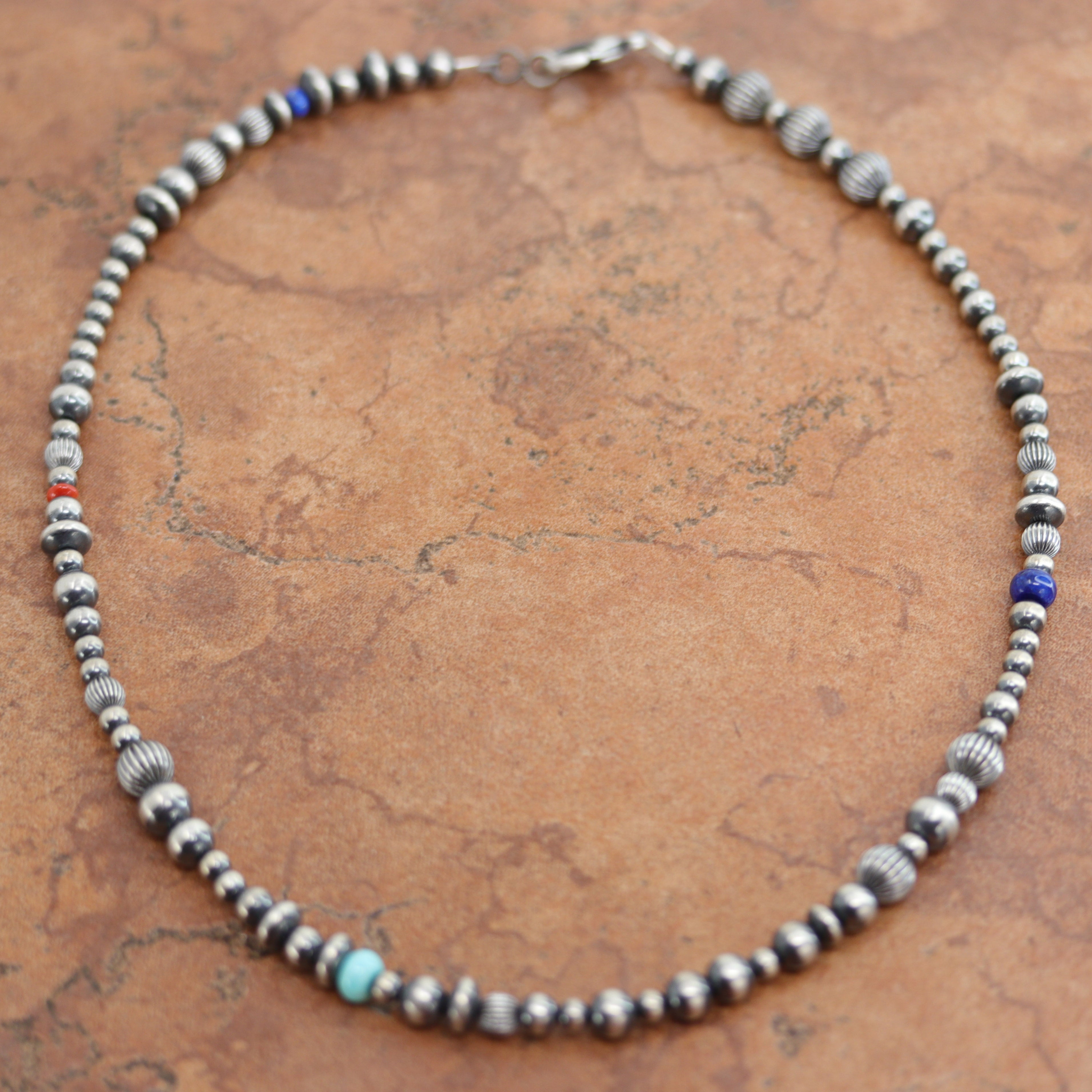 A beautiful silver Navajo Native American multi-stone necklace. The necklace is 18" in length and the beads measure 3/8". 