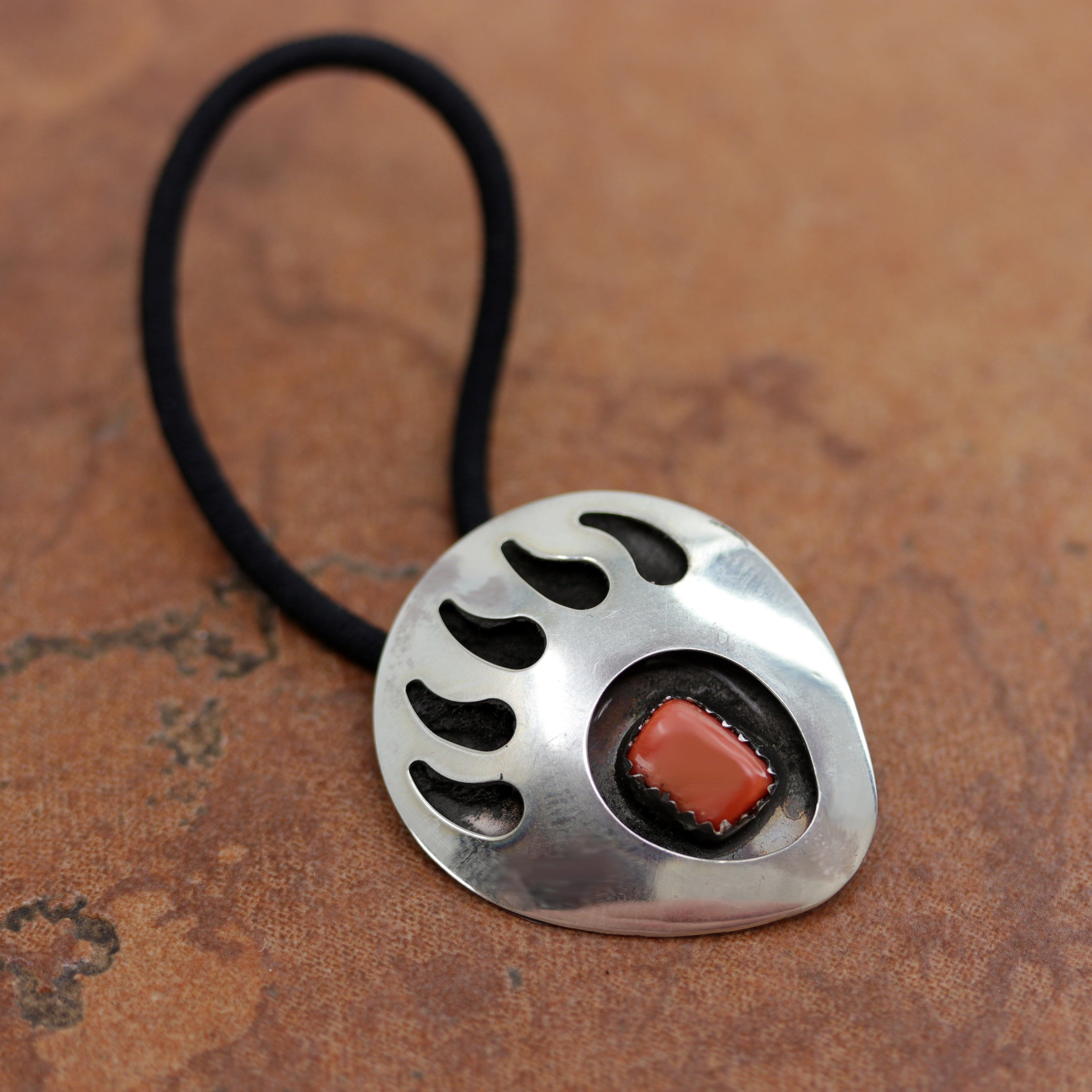 Beautiful Navajo Native American bear paw shaped hair tie made from a hair band, sterling silver, and coral. It is 2 3/4" long (including the hair tie) and 1 1/8" wide.