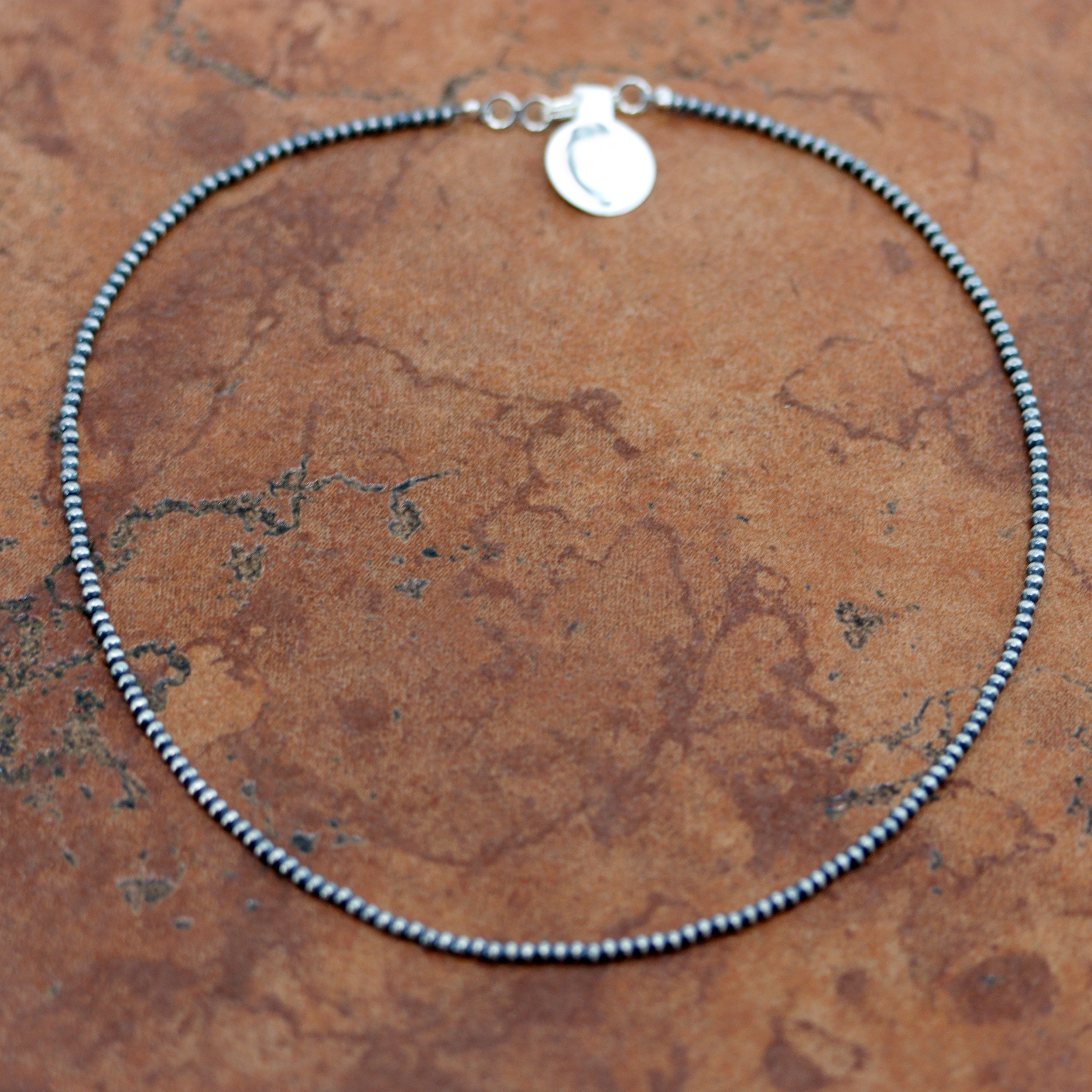 A beautiful silver Navajo Pearl Native American choker necklace. The necklace is 14" in length and the beads measure 3 mm.