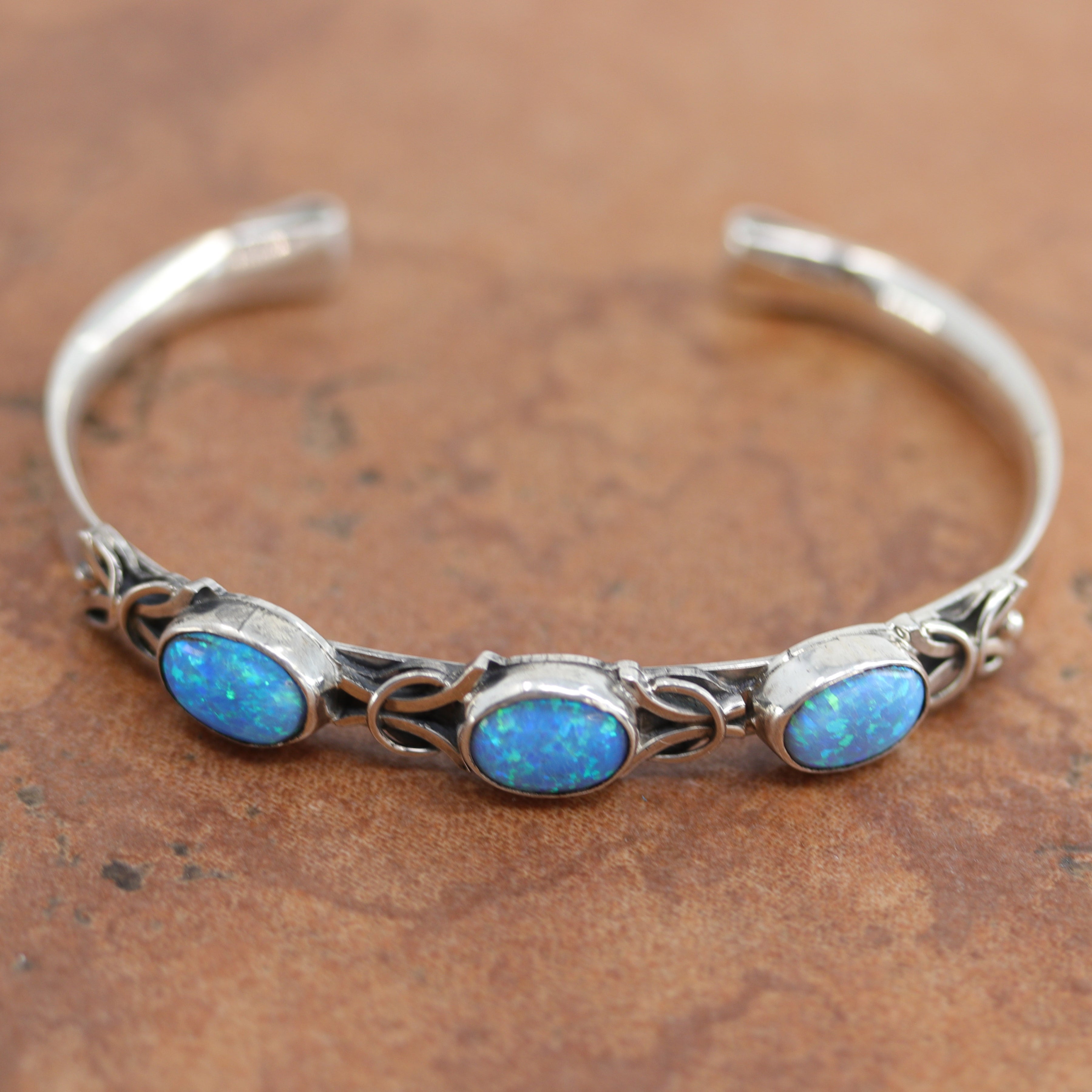Navajo Native American bracelet by Thomas Yazzie. It is made from sterling silver and created opal. It is about 5 1/4" around and 3/8" wide. The opening is about 1", and it is partly flexible.