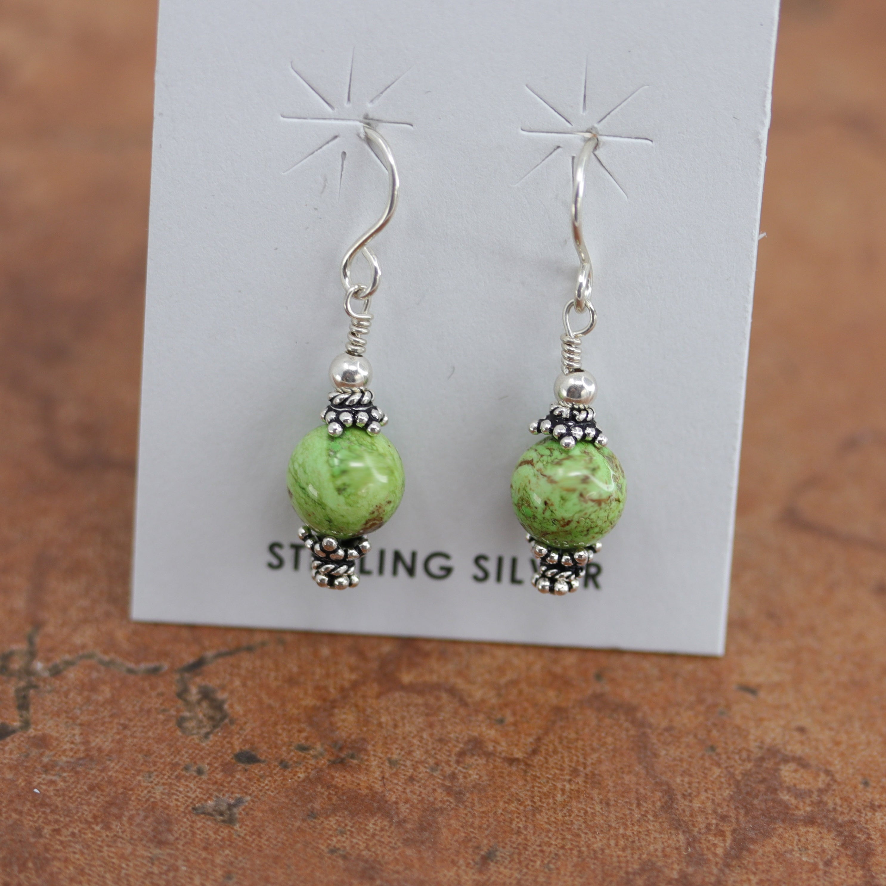 Beautiful Native American earrings made from sterling silver and gaspeite. The earrings are about 1 1/4" in length including the hook and 1/4" wide.