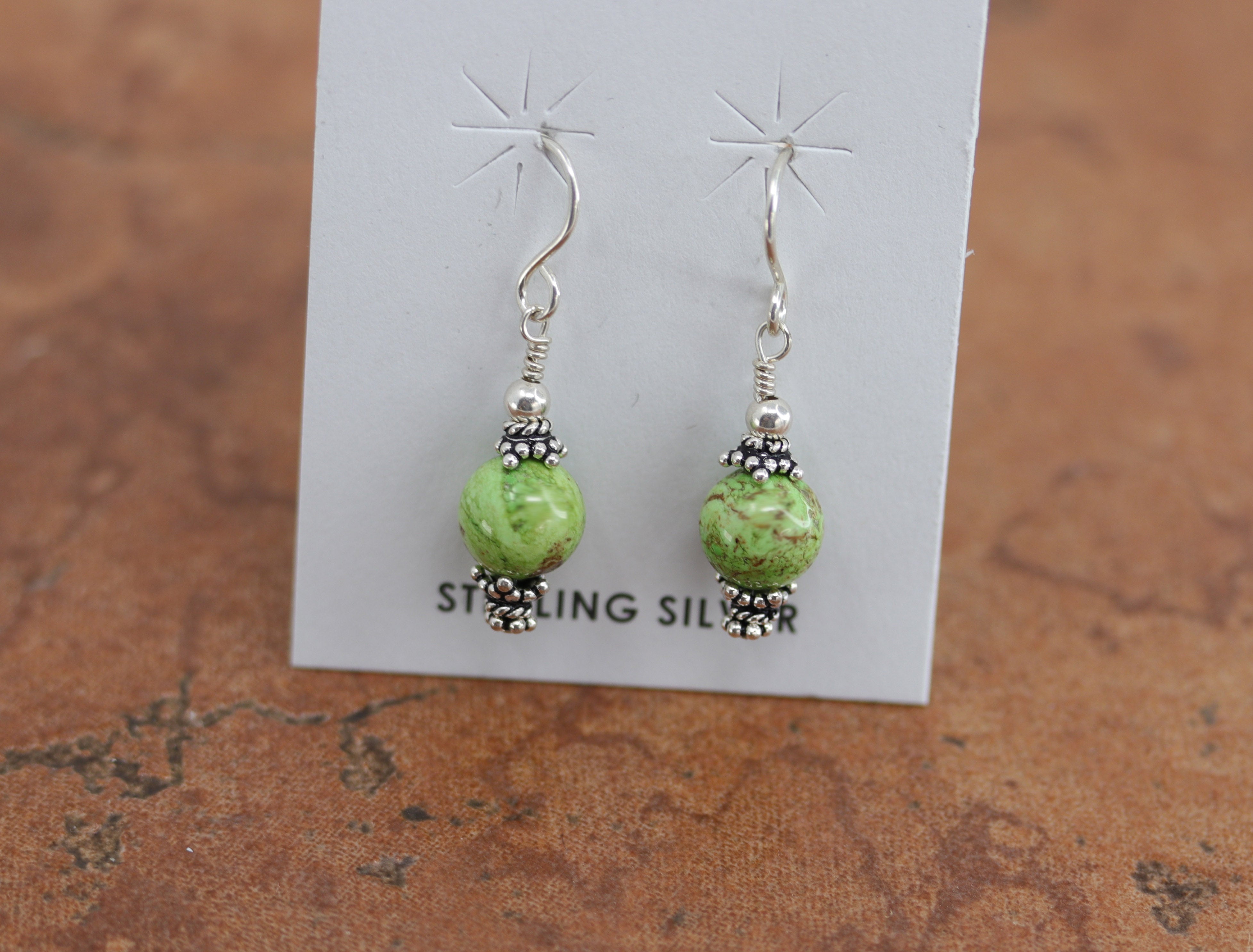 Beautiful Native American earrings made from sterling silver and gaspeite. The earrings are about 1 1/4" in length including the hook and 1/4" wide.