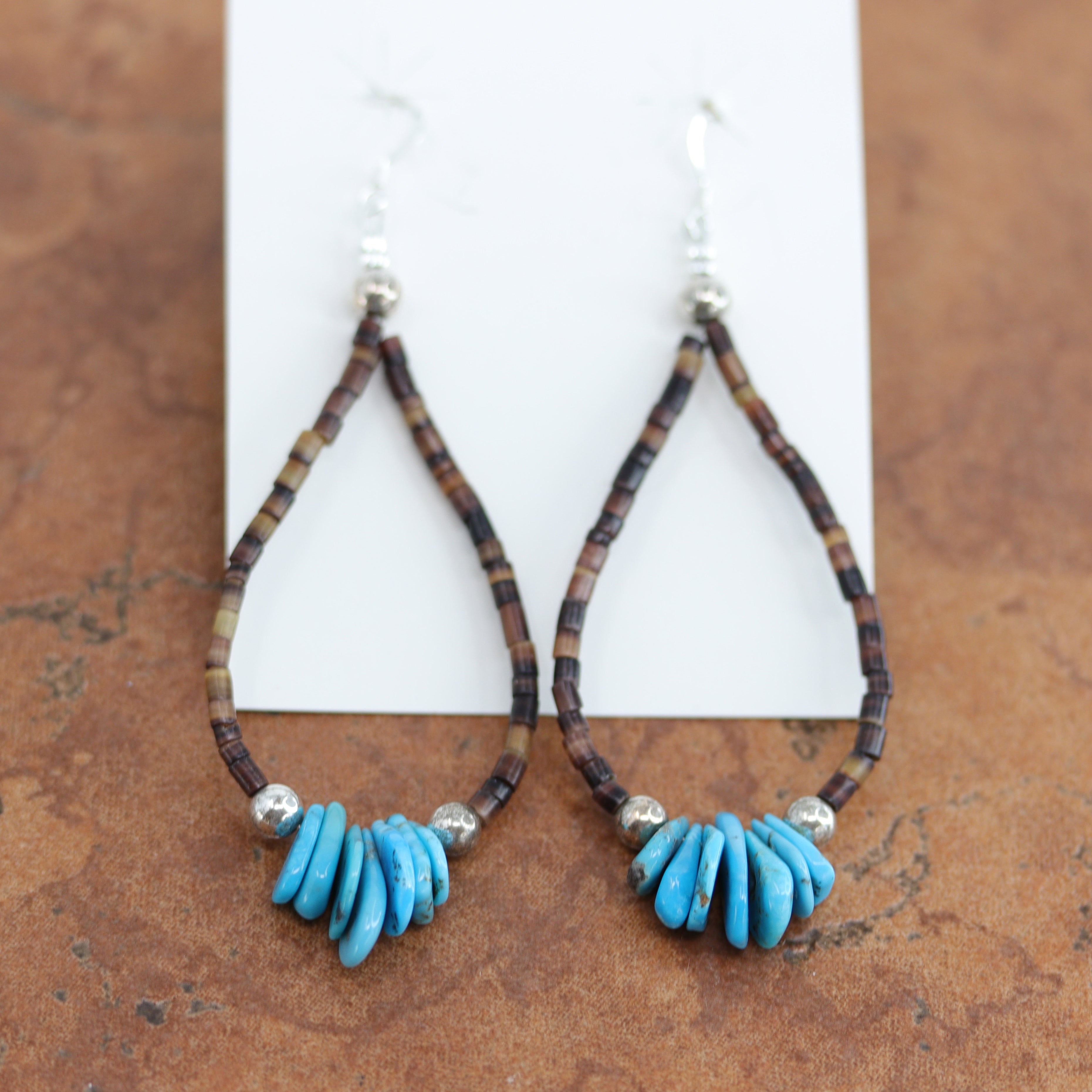 Navajo Native American silver earrings. They are made from sterling silver, heishi, and spiny oyster. The earrings about 3 1/2" long including the hook and about 1 1/4" in width.