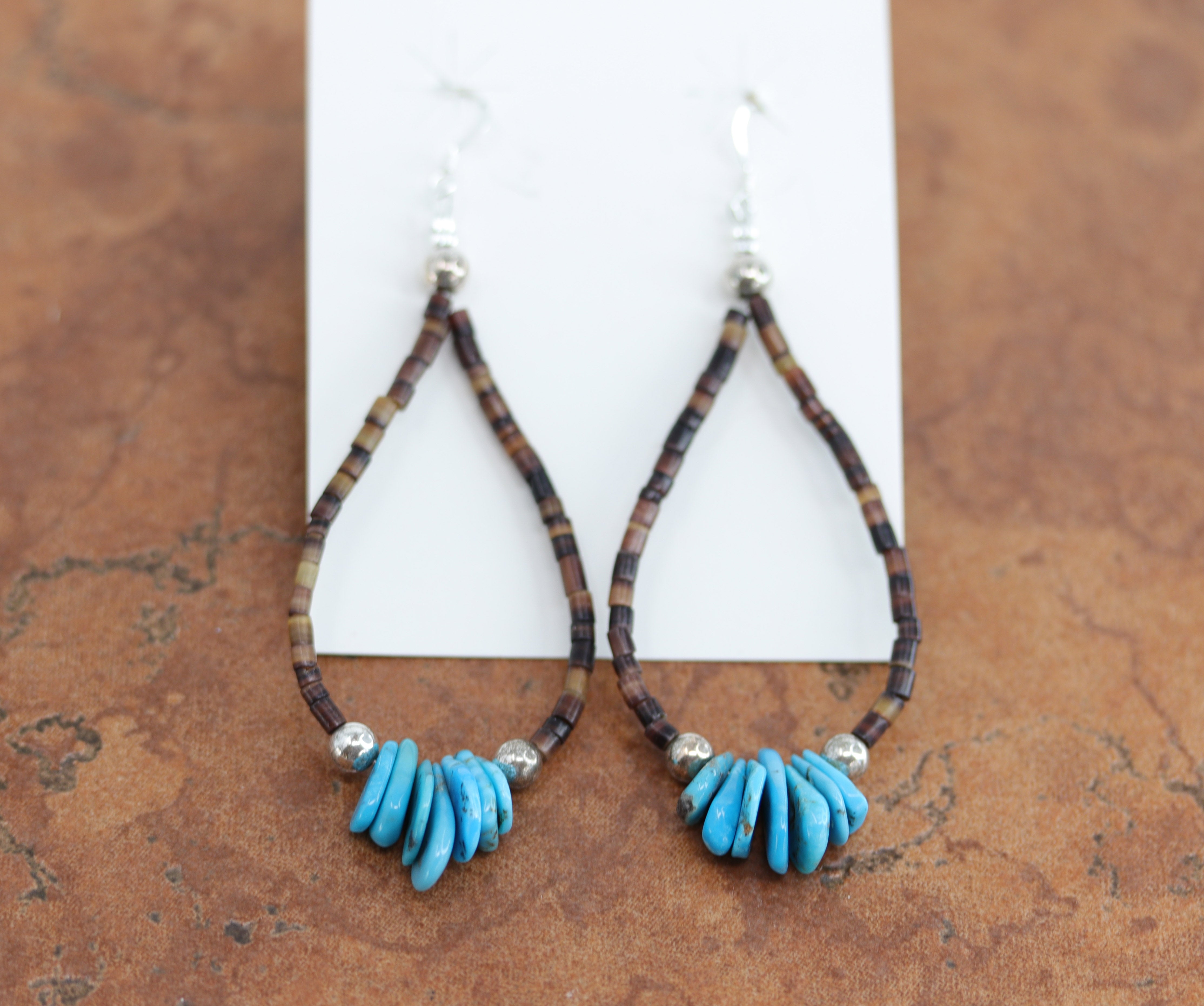 Navajo Native American silver earrings. They are made from sterling silver, heishi, and spiny oyster. The earrings about 3 1/2" long including the hook and about 1 1/4" in width.