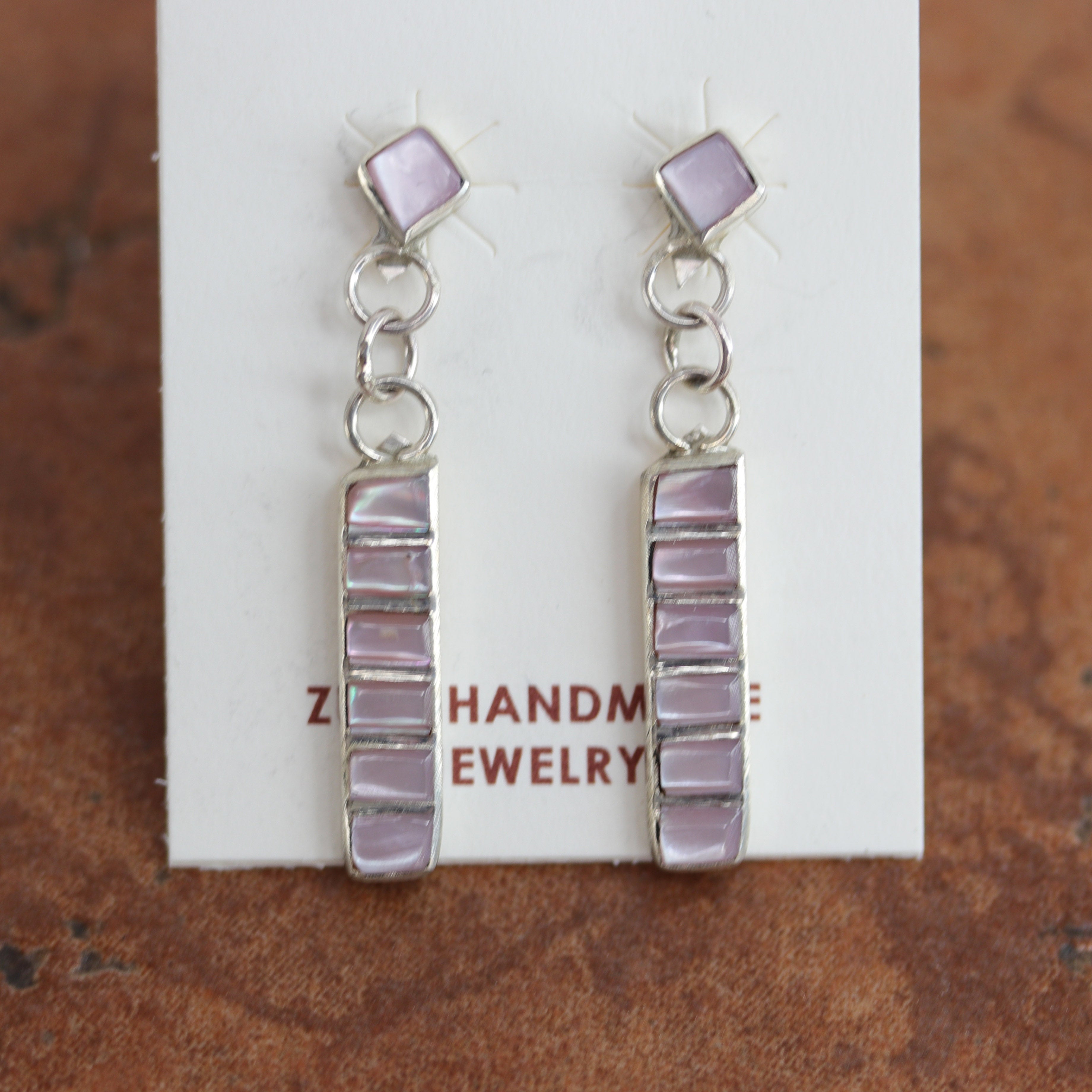 Brand new, very nice, Zuni Native American earrings. They are made from sterling silver and mother of pearl. The earrings are about 1 5/8" in length and 1/4" in width.