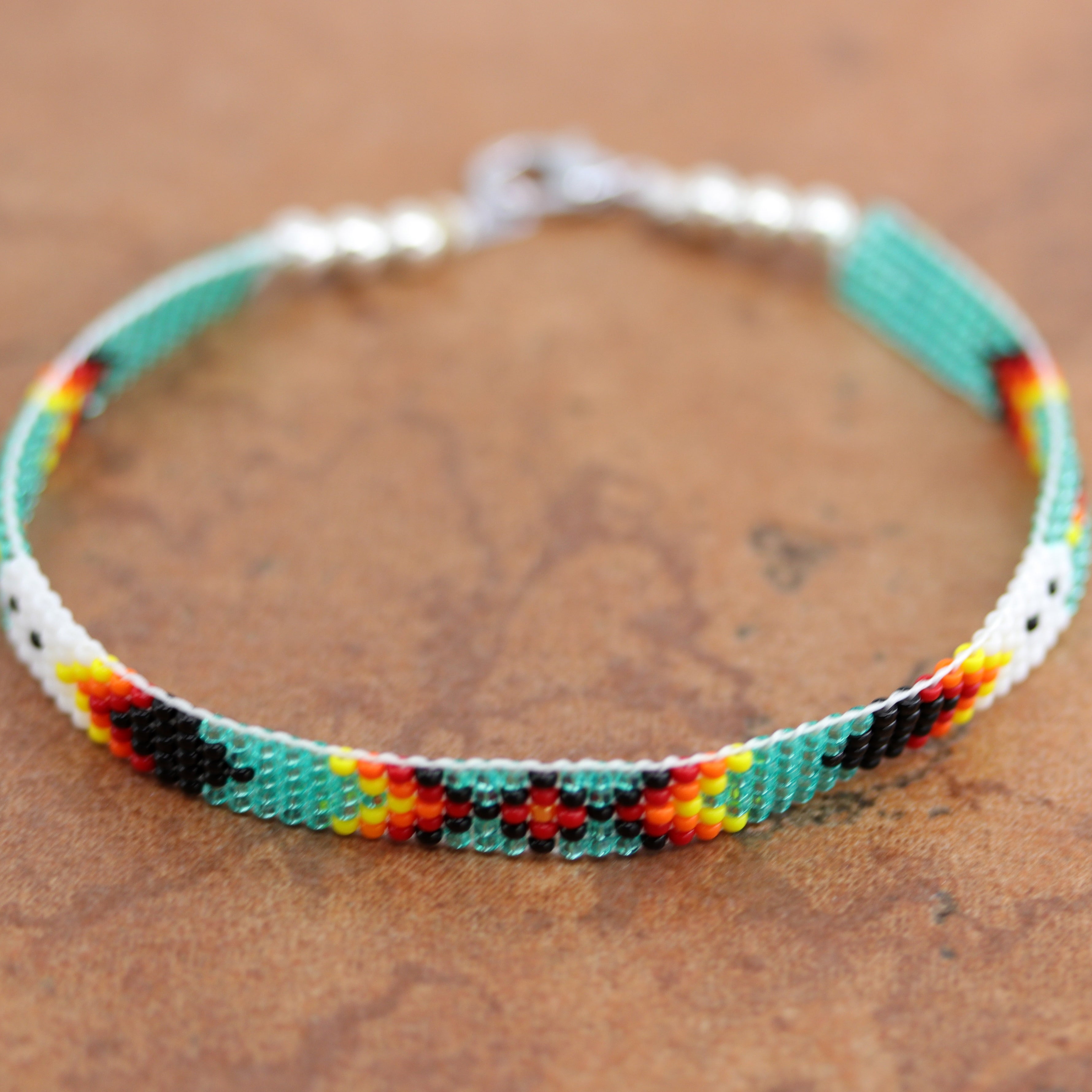 A beautiful Navajo green and white beaded bracelet. It is about 7 7/8" from end to end and the width is 1/4" at the widest point.