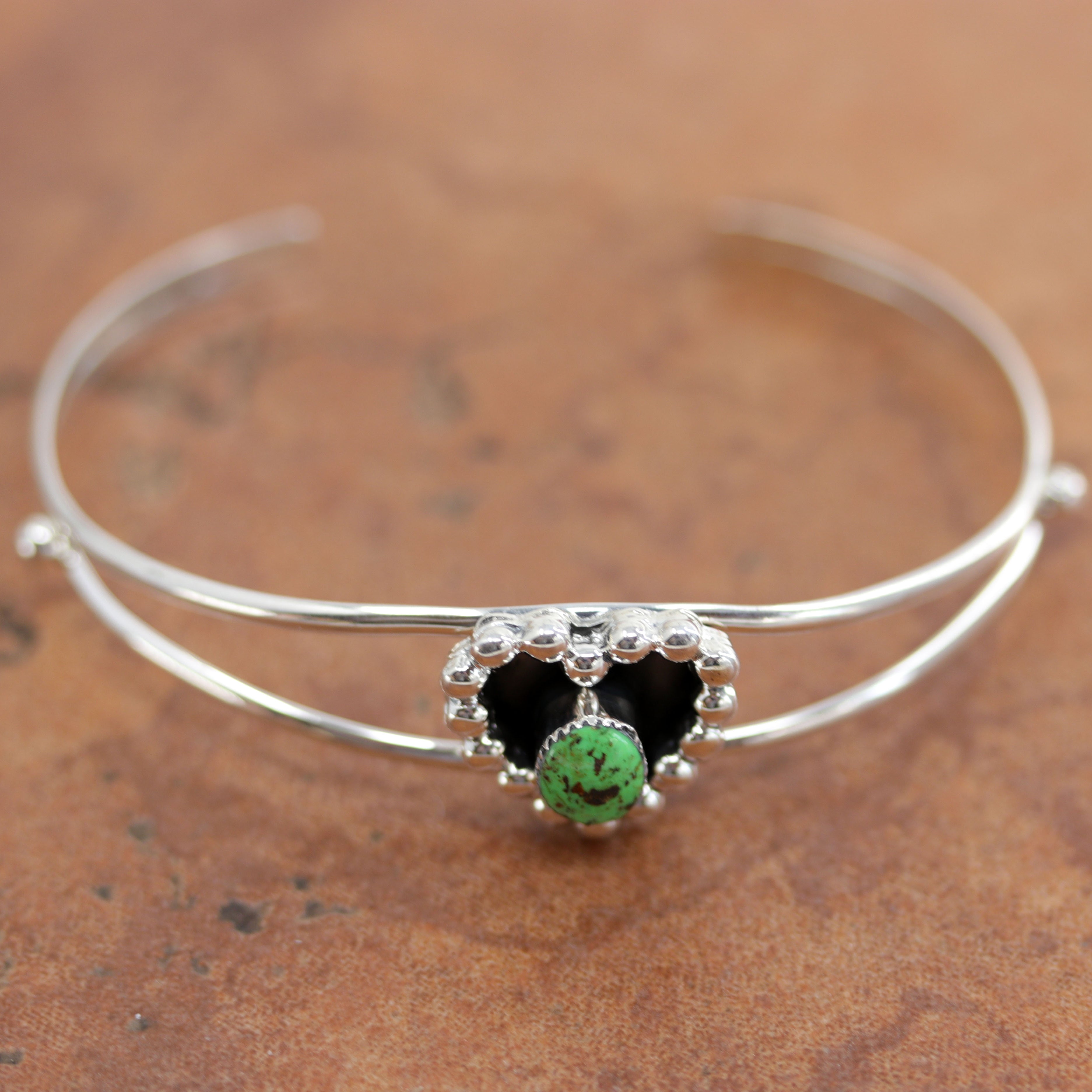 A beautiful Navajo Native American bracelet by Marie Bahe. It is made from sterling silver and green turquoise. It is about 5 3/4" around and 3/4" wide. The opening is about 1 1/4", and partly flexible.