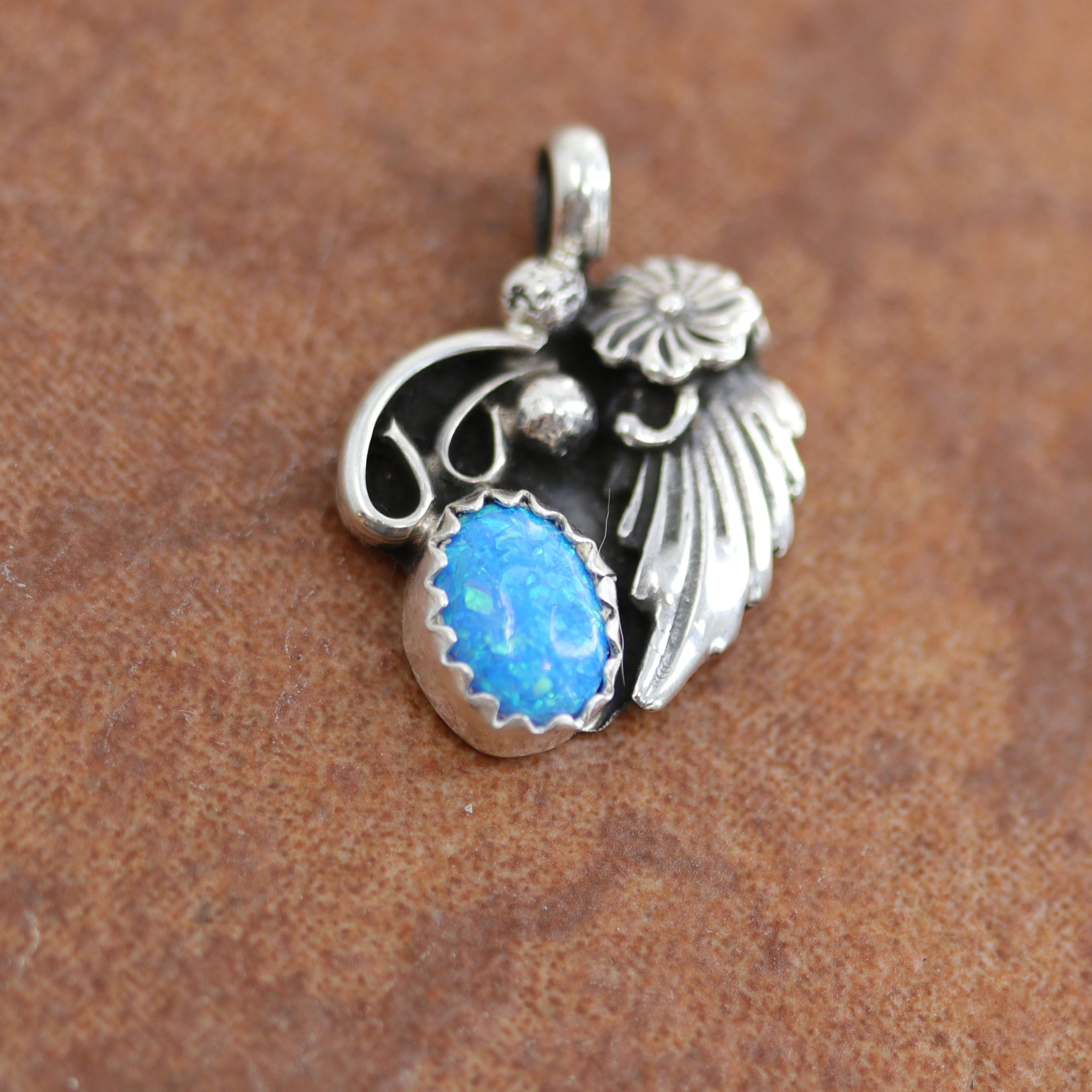 Navajo Native American Pendant. It is made from sterling silver and created opal. It is 3/4" long, and about 5/8" wide.