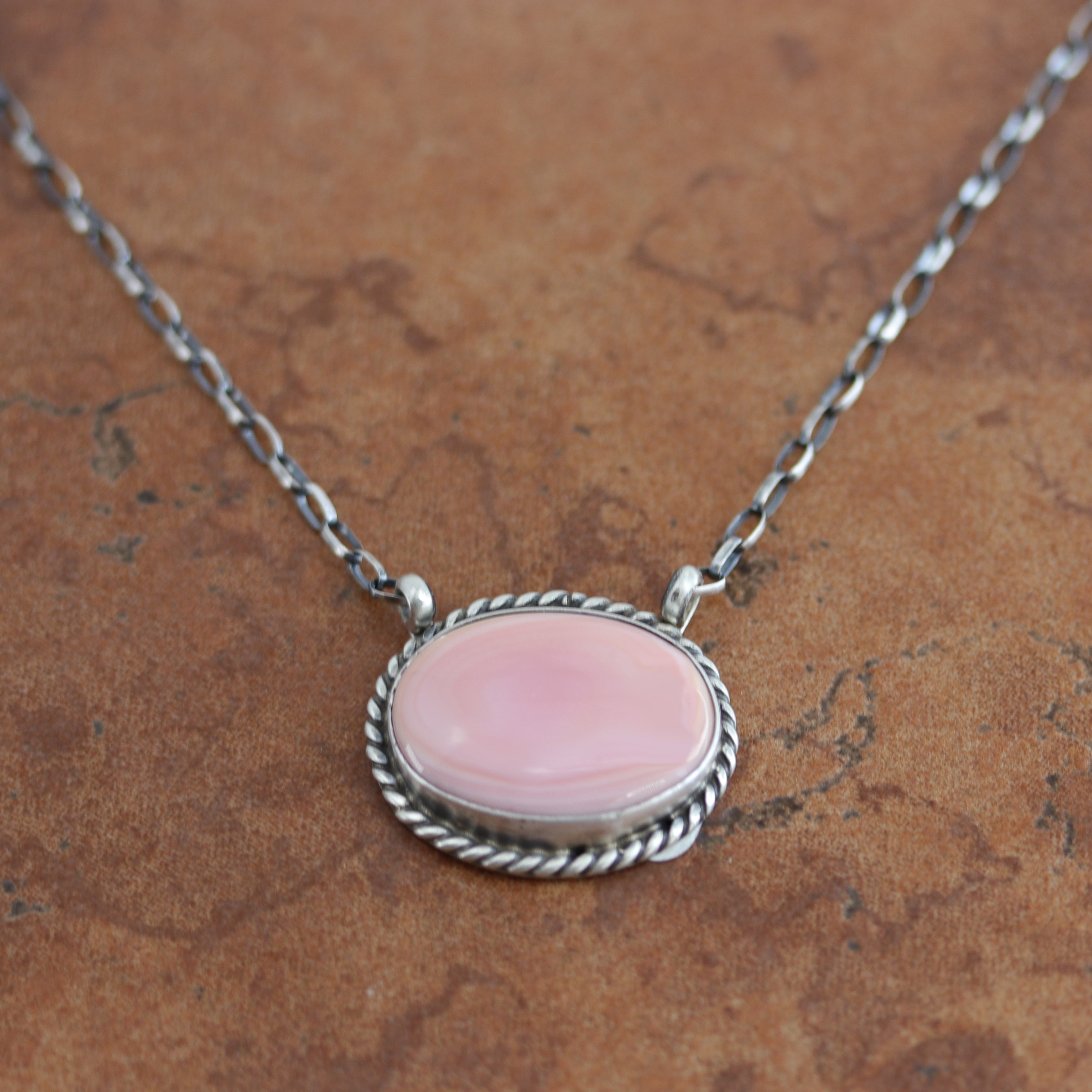 A beautiful necklace made by Eugene Balone. It is made from sterling silver and pink quartz. The necklace is about 17" in length. The center measures 1 1/8" in width. 