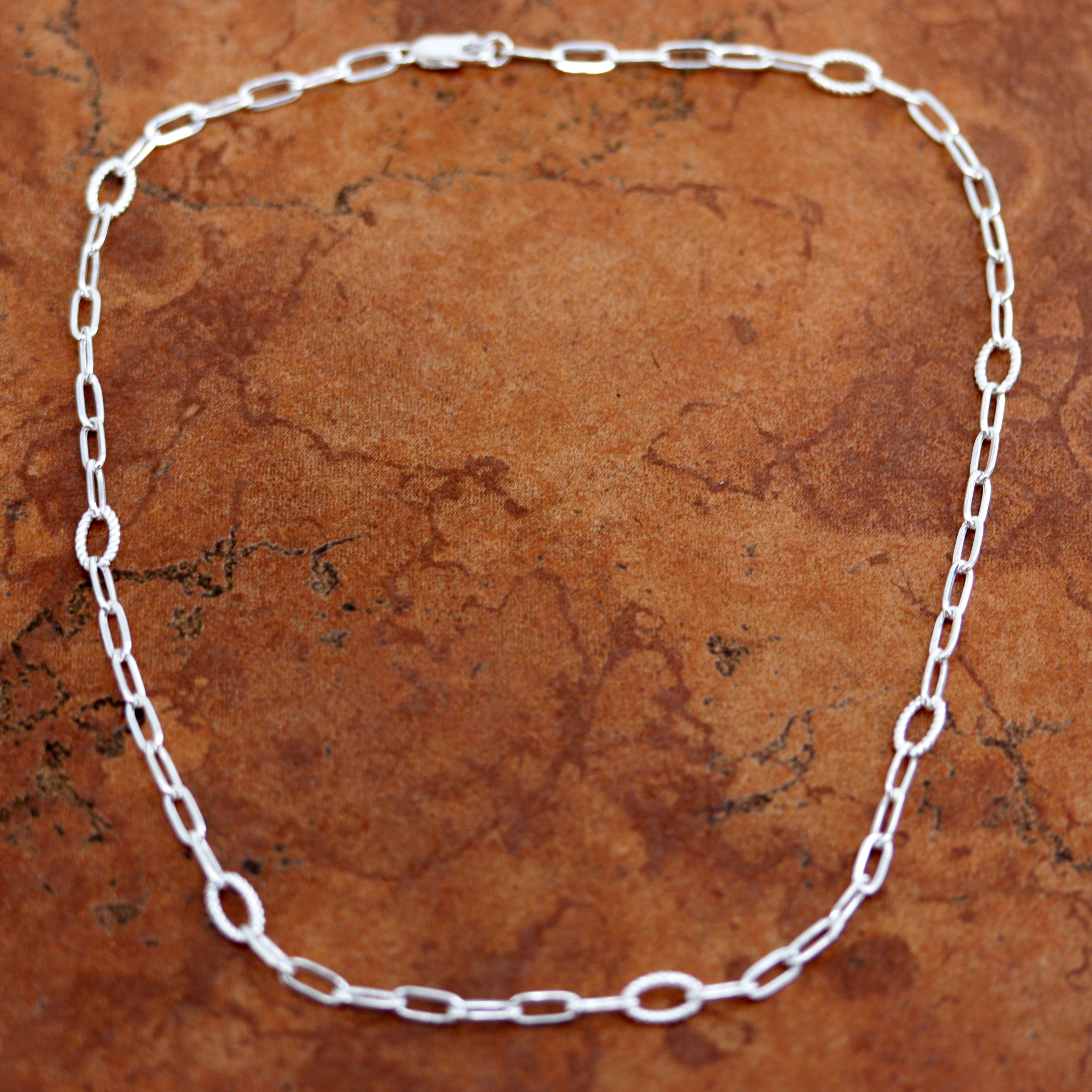 A Beautiful Paper Clip Chain Link Necklace. It is made from .925 sterling silver. The length is about 18" and the width is 3/16".