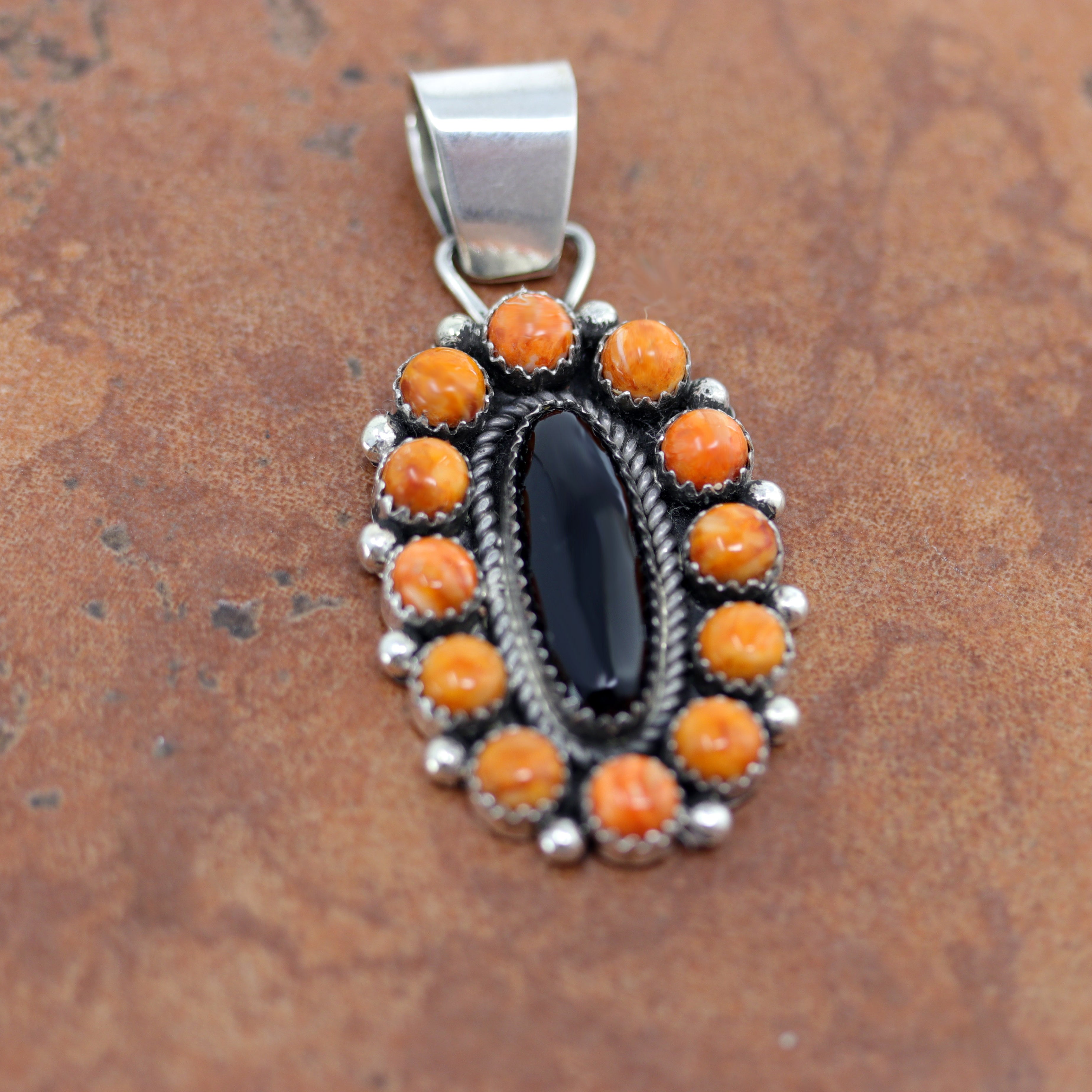 A Beautiful Navajo Native American Pendant. It is made from sterling silver and spiny oyster. The pendant is about 2 1/4" in length and 1" in width.