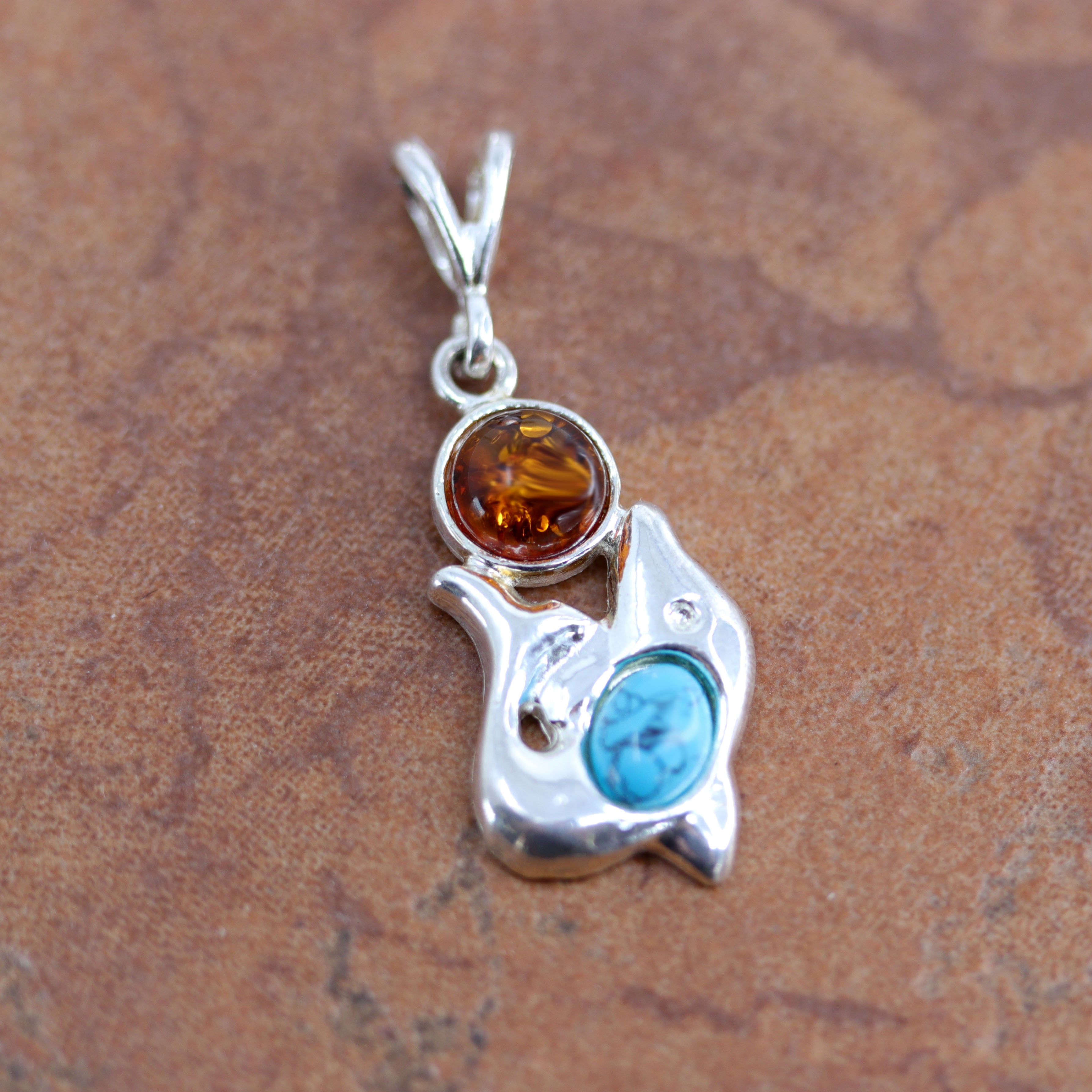 It is made from sterling silver and Baltic amber. The pendant is 1 1/2" in length including the bail, and 5/8" in width.