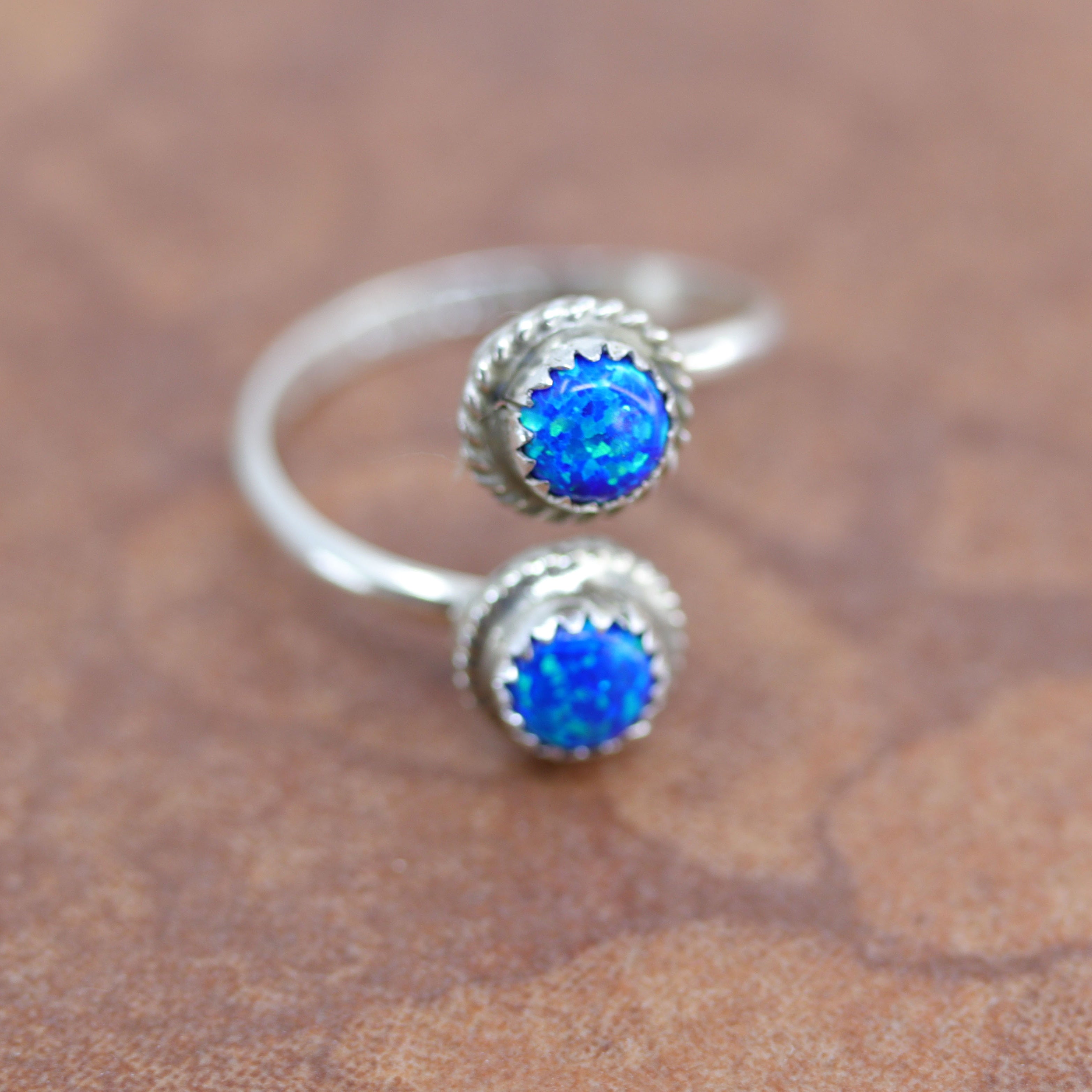 A beautiful Navajo Native American ring by Esther White. It is made from sterling silver and created opal. The size is adjustable so it can fit sizes 6-9, and it is 3/4" at the widest point.