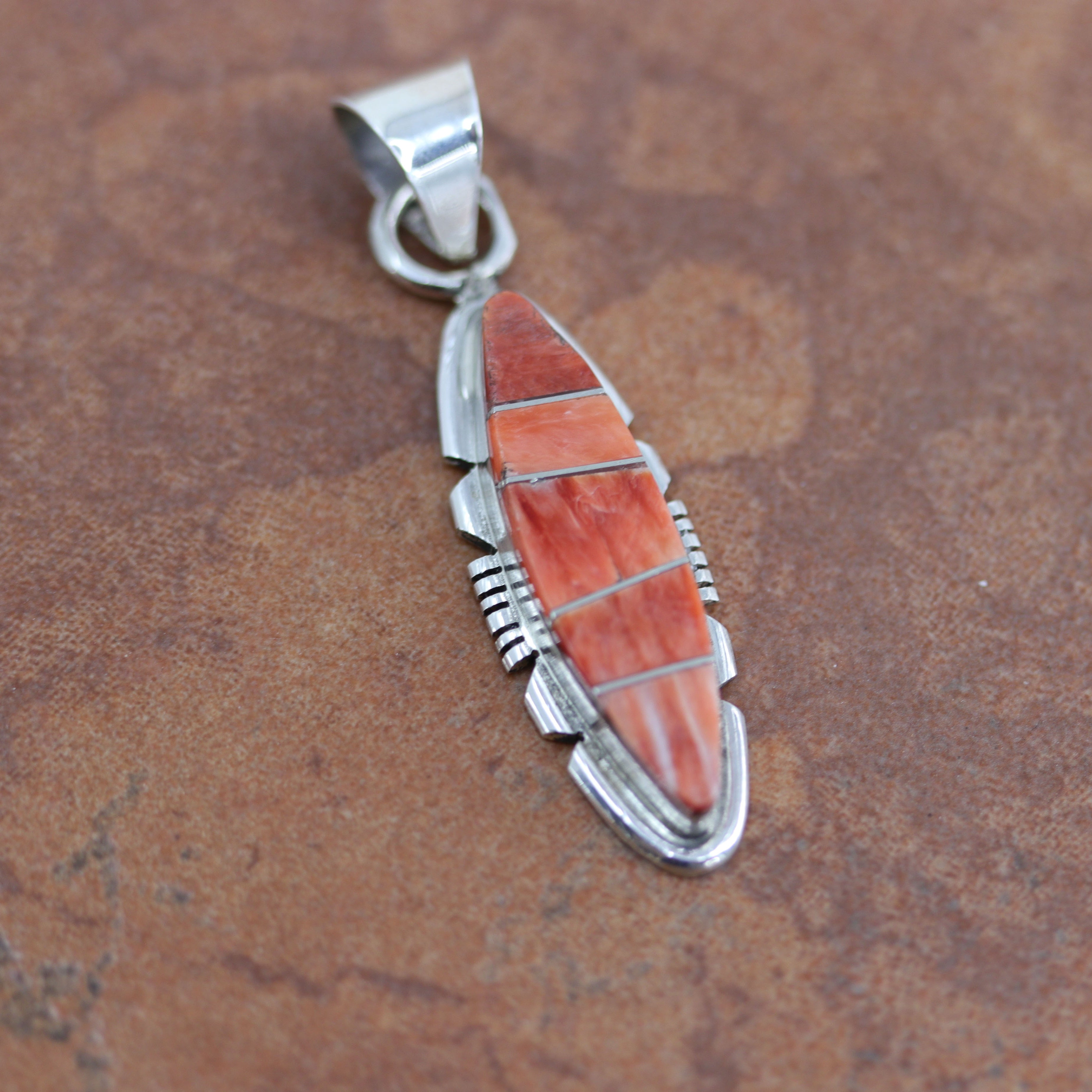 Lovely Navajo Native American Pendant by B Etsitty. It is made from sterling silver and spiny oyster. It is 2" long and about 1/2" wide.