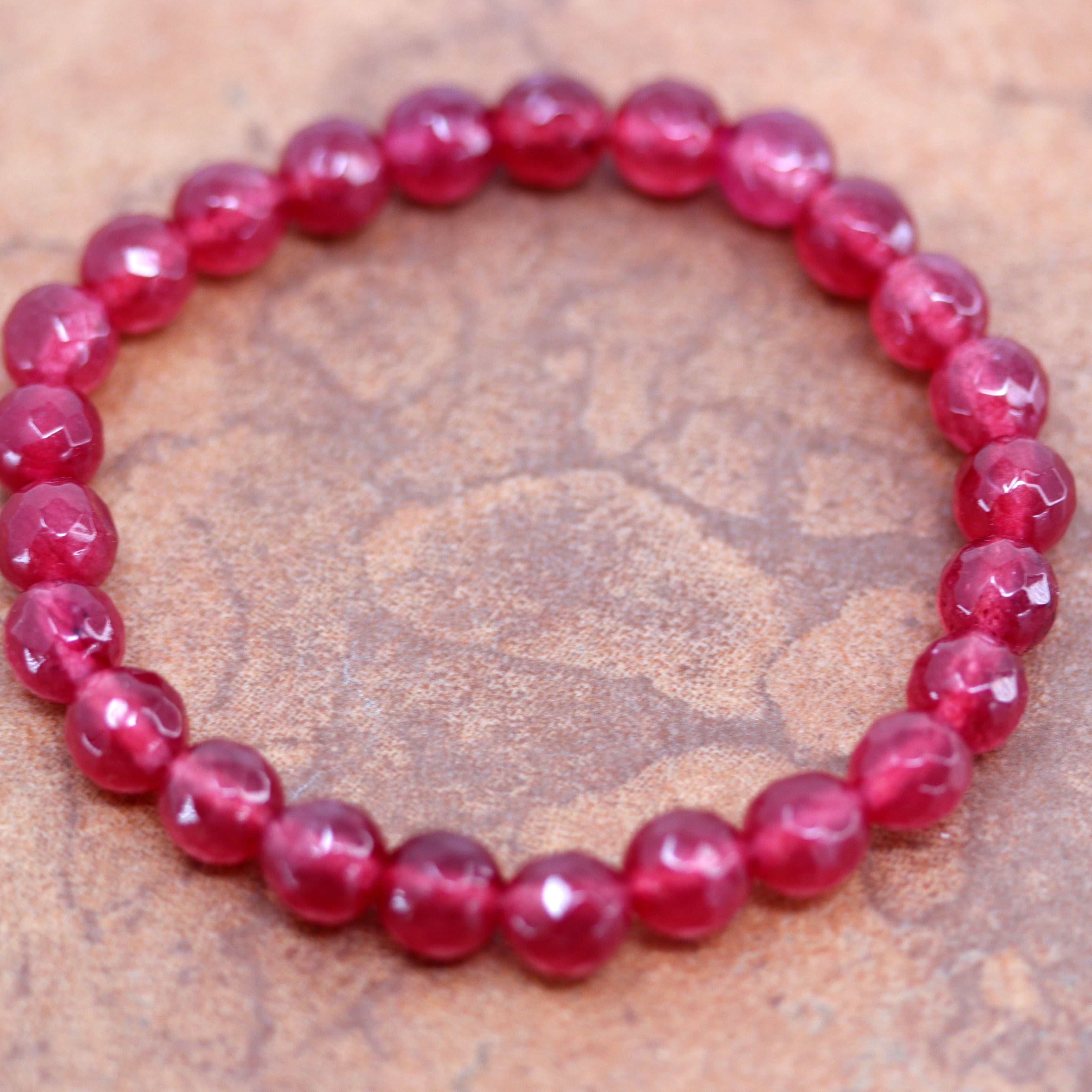 It fits sizes 6" (more loose) to about 9" (tighter fit). The width of the bracelet is 8 mm. It is made from red jade.