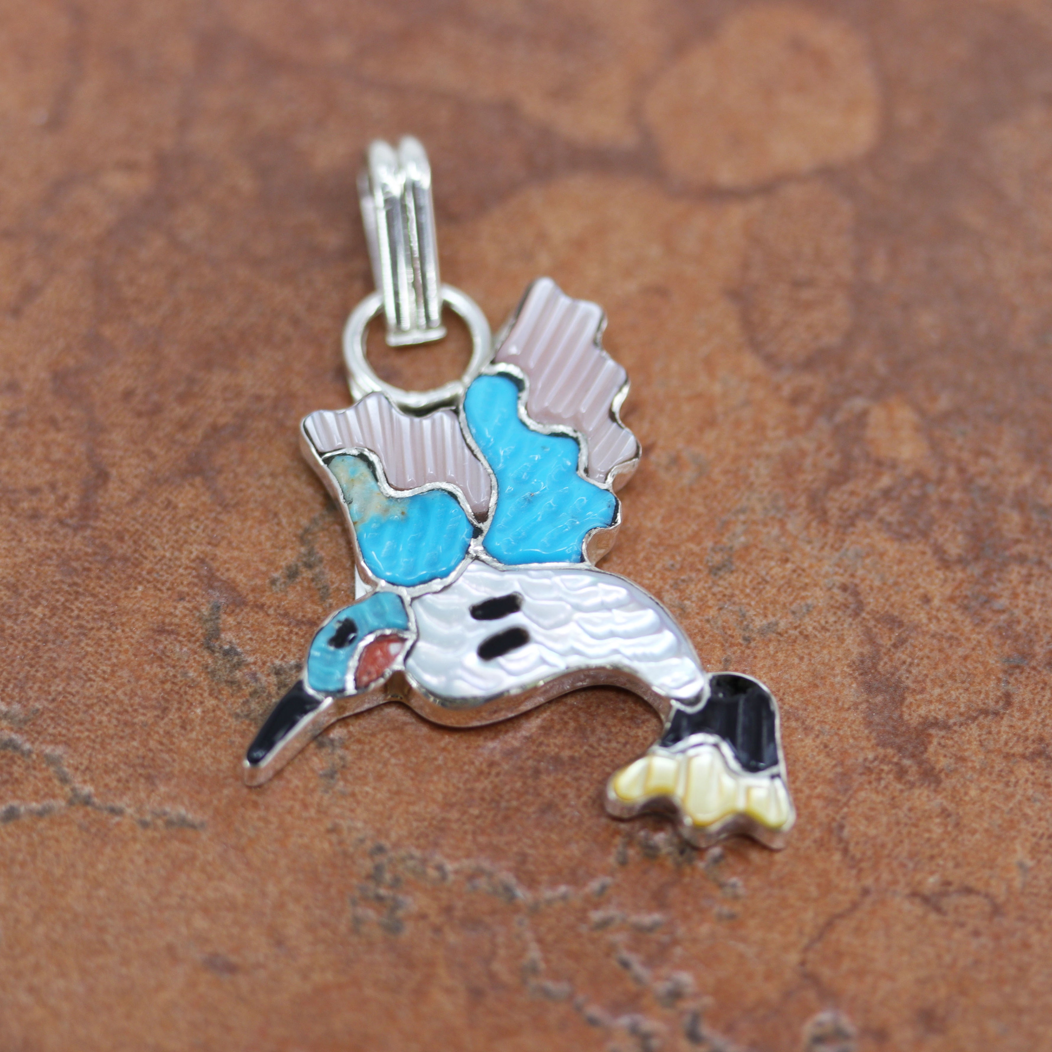 Zuni Native American Pendant. It is made from sterling silver and multi-stone inlay. It is 1 1/4" in width and 2" in length.