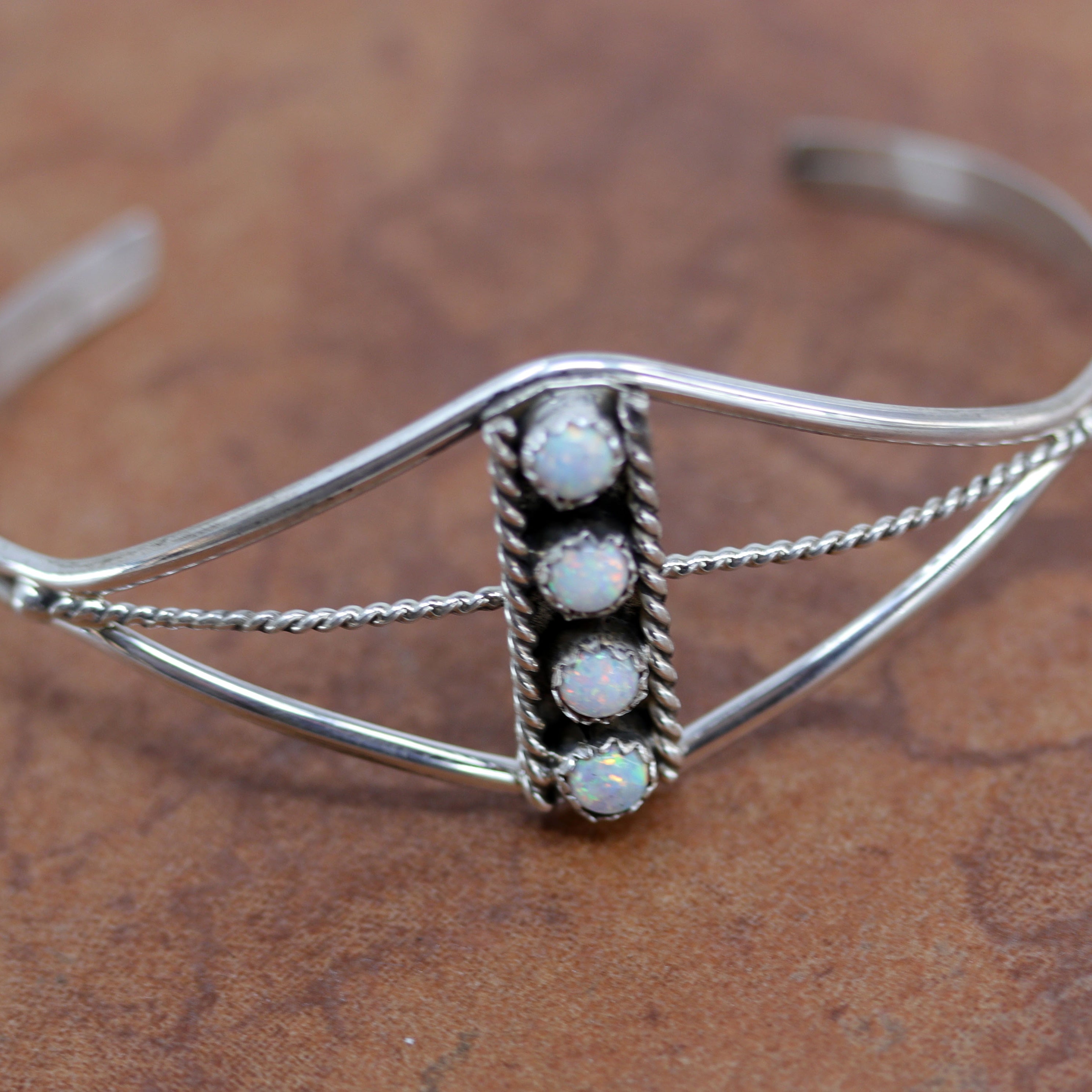 Beautiful Navajo Native American bracelet. It is made from sterling silver and created opal. It is about 5 1/4" around and 1" wide. The opening is about 1 1/2", and partly flexible.