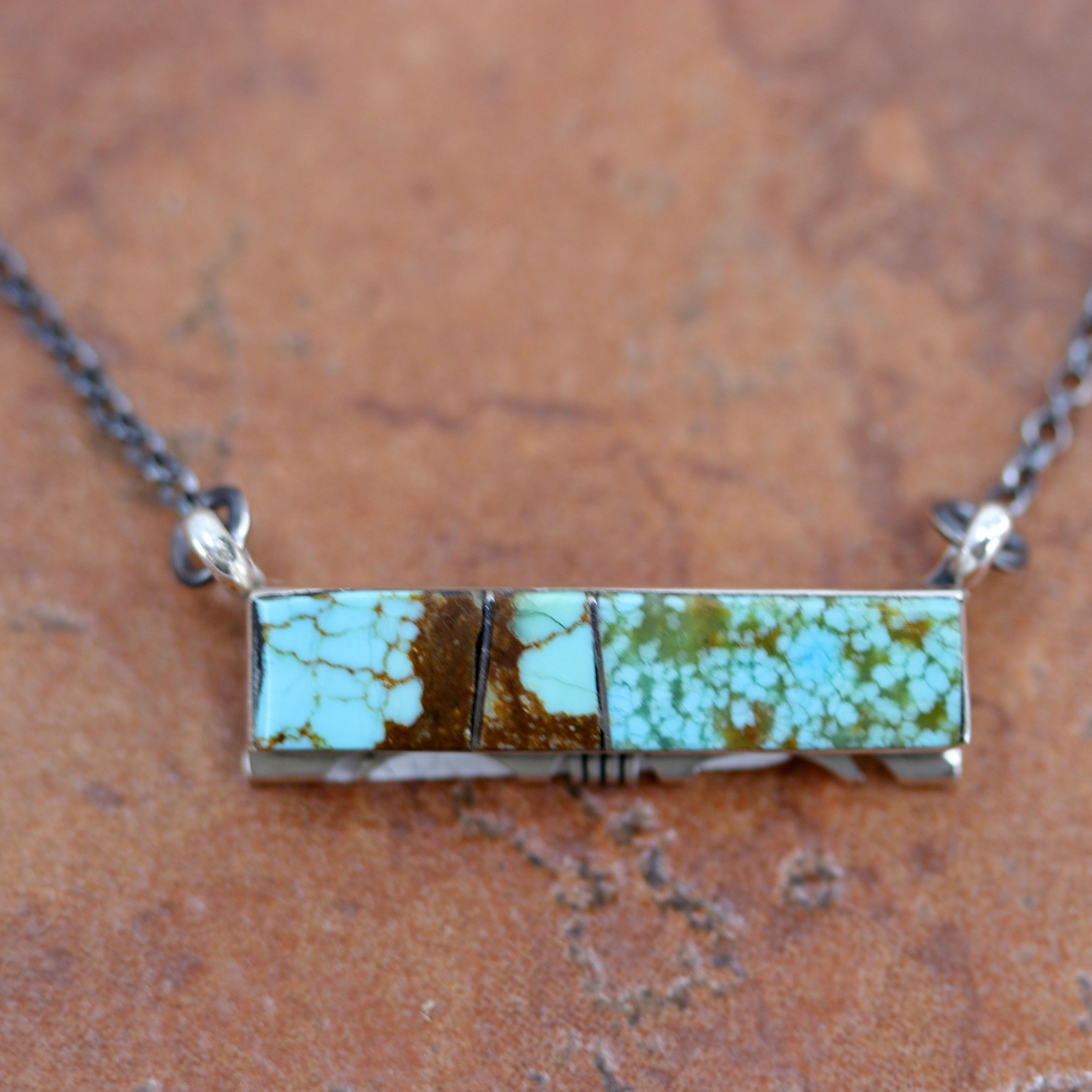 A beautiful Navajo Native American necklace by Steve Francisco. It is made from sterling silver, and turquoise. The necklace is about 18" in length. The center pendant measures 7/16".