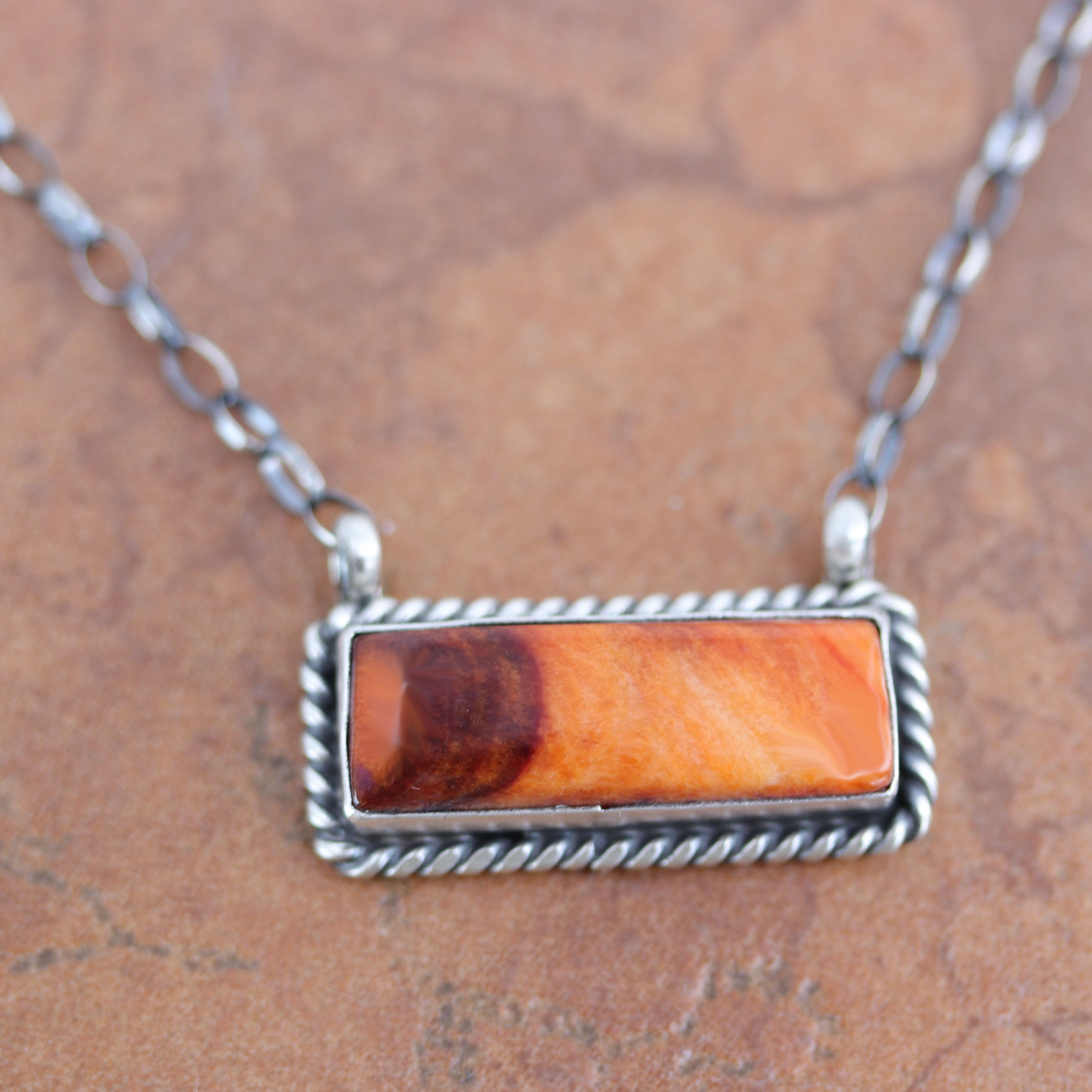 A beautiful Navajo Native American necklace. It is made from sterling silver, and spiny oyster. The necklace is about 17" in length. The center pendant measures 1 1/8" by 5/8".