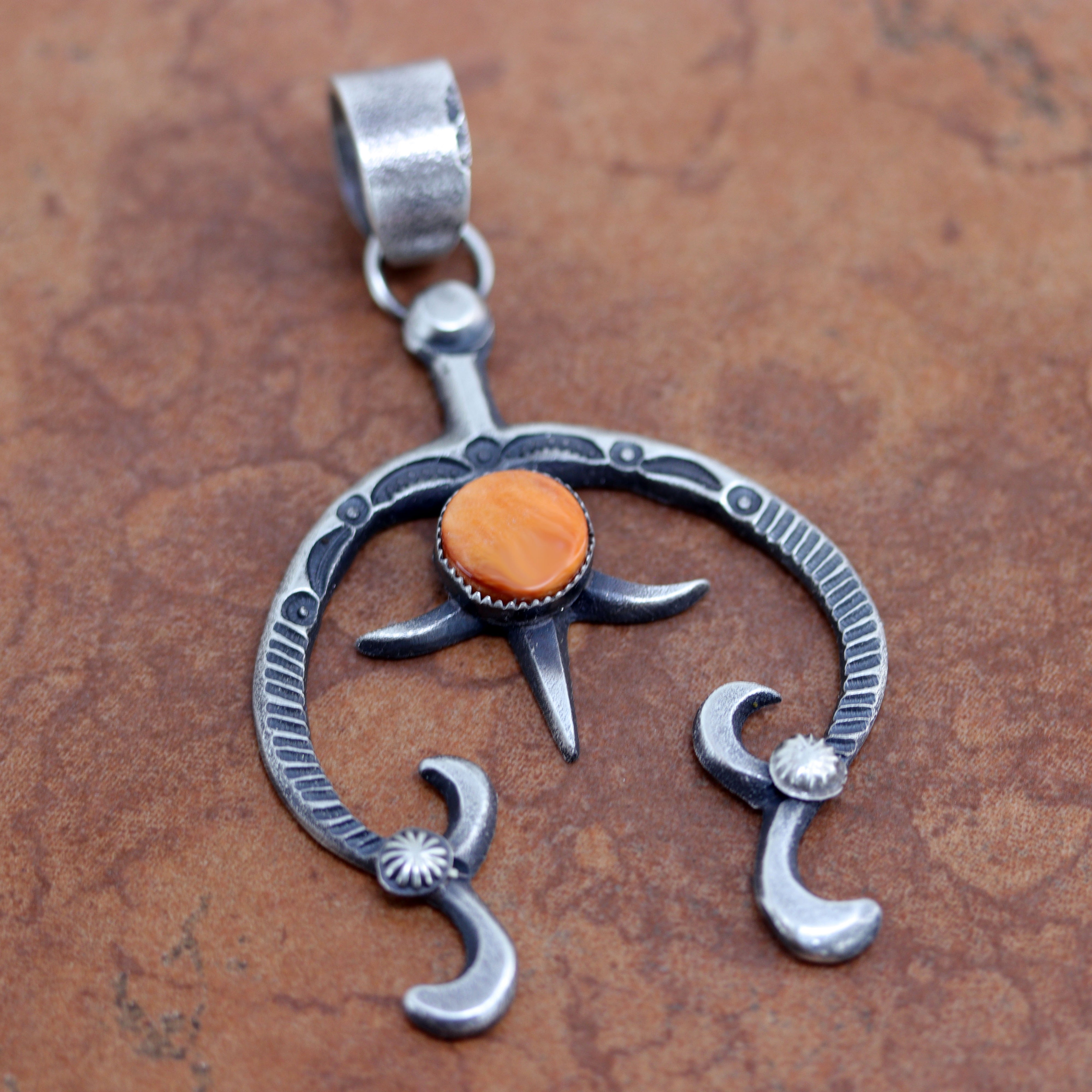 A beautiful Navajo Native American Pendant. It is made from sterling silver and spiny oyster. It is 3 3/4" long and about 2 1/4" wide.