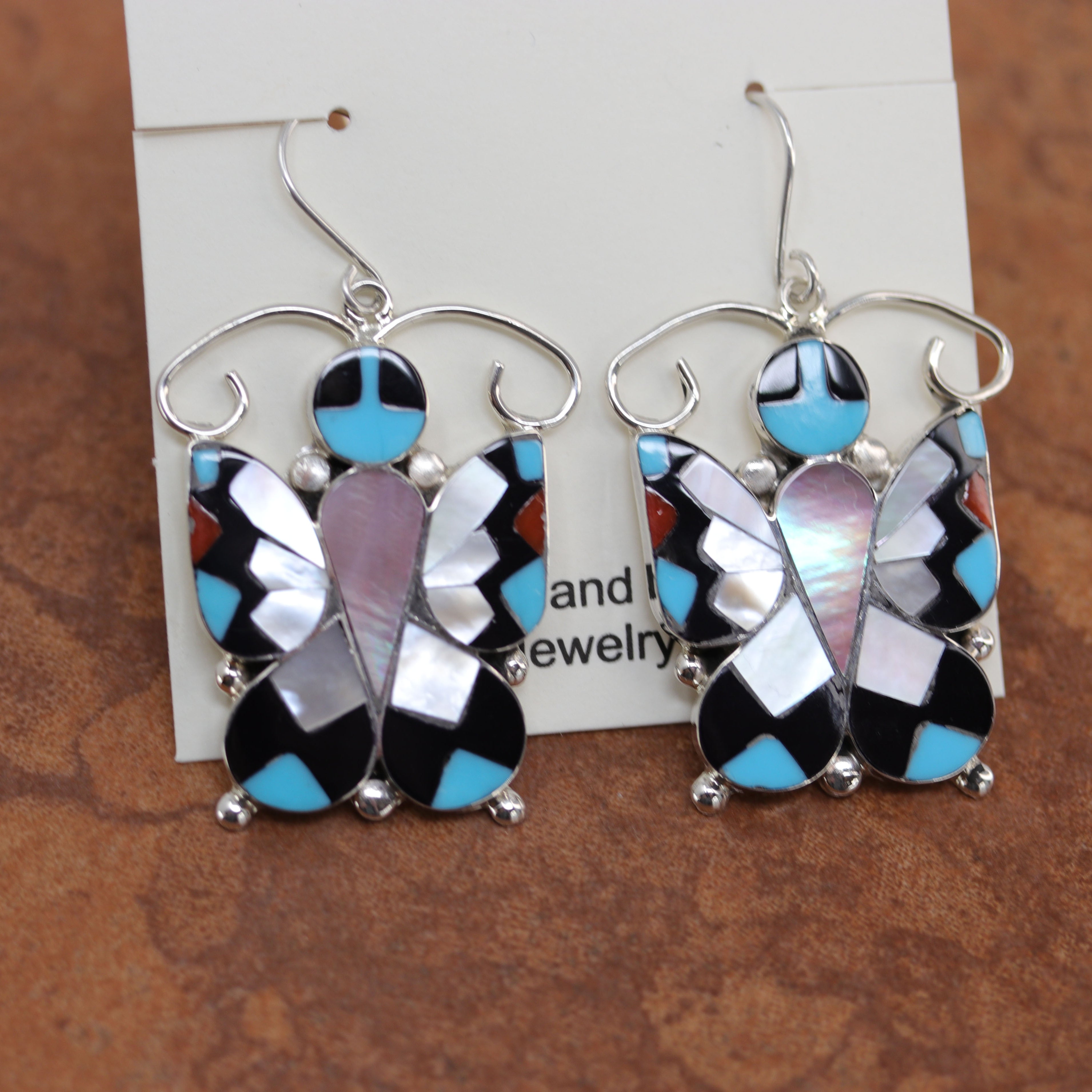 Authentic Zuni Native American earrings by A Dishta. They are made from sterling silver and multi-stone inlay. The earrings are 2 1/8" in length including the hook and 1 3/8" in width.