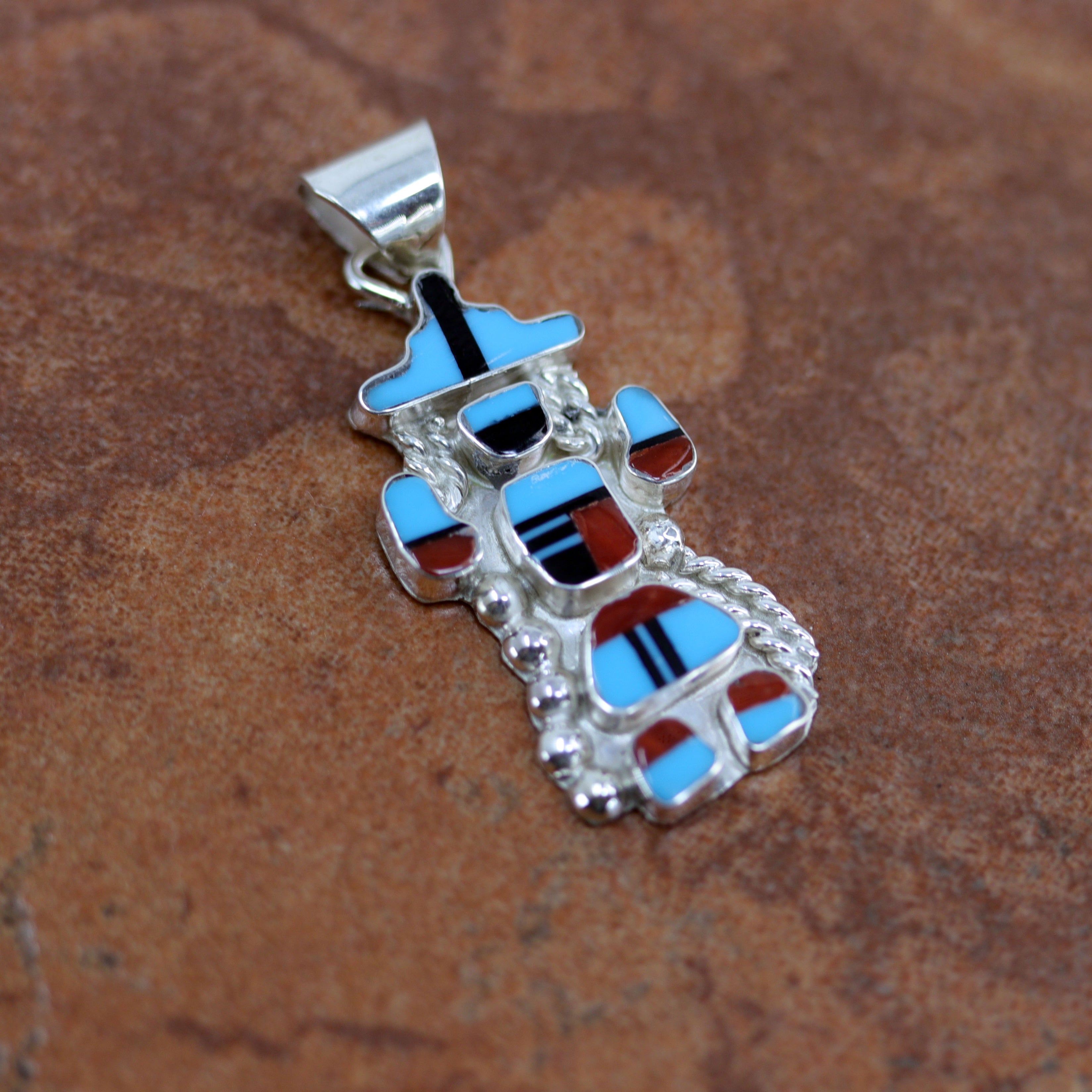Zuni Native American Pendant. It is made from sterling silver and multi-stone inlay. It is 5/8" in width and 1 1/2" in length including the bail.