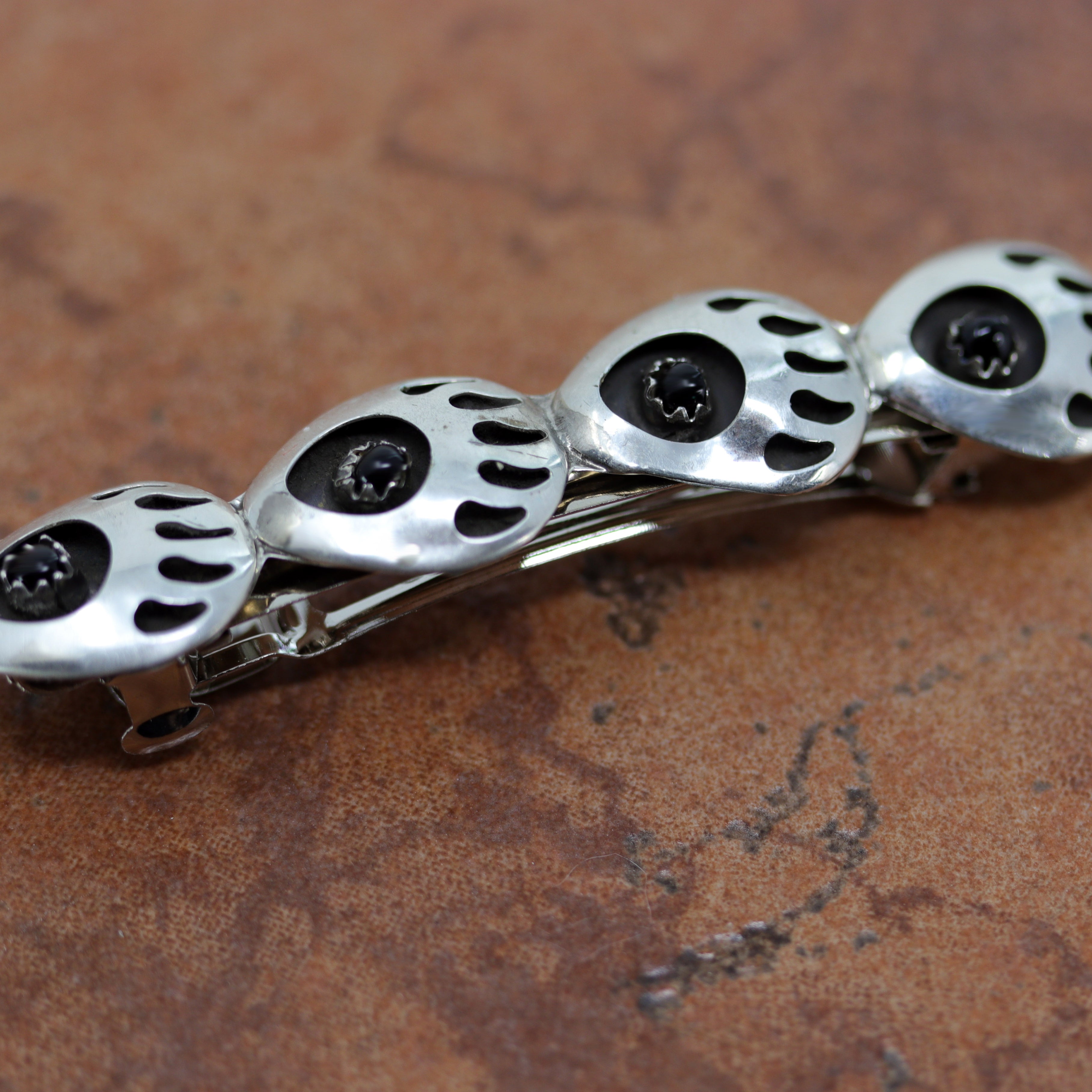 Gorgeous Navajo Native American Barrette made from sterling silver and onyx. The stones are inside bear paw designs. It is 5/8" long, and about 2 3/4" wide.