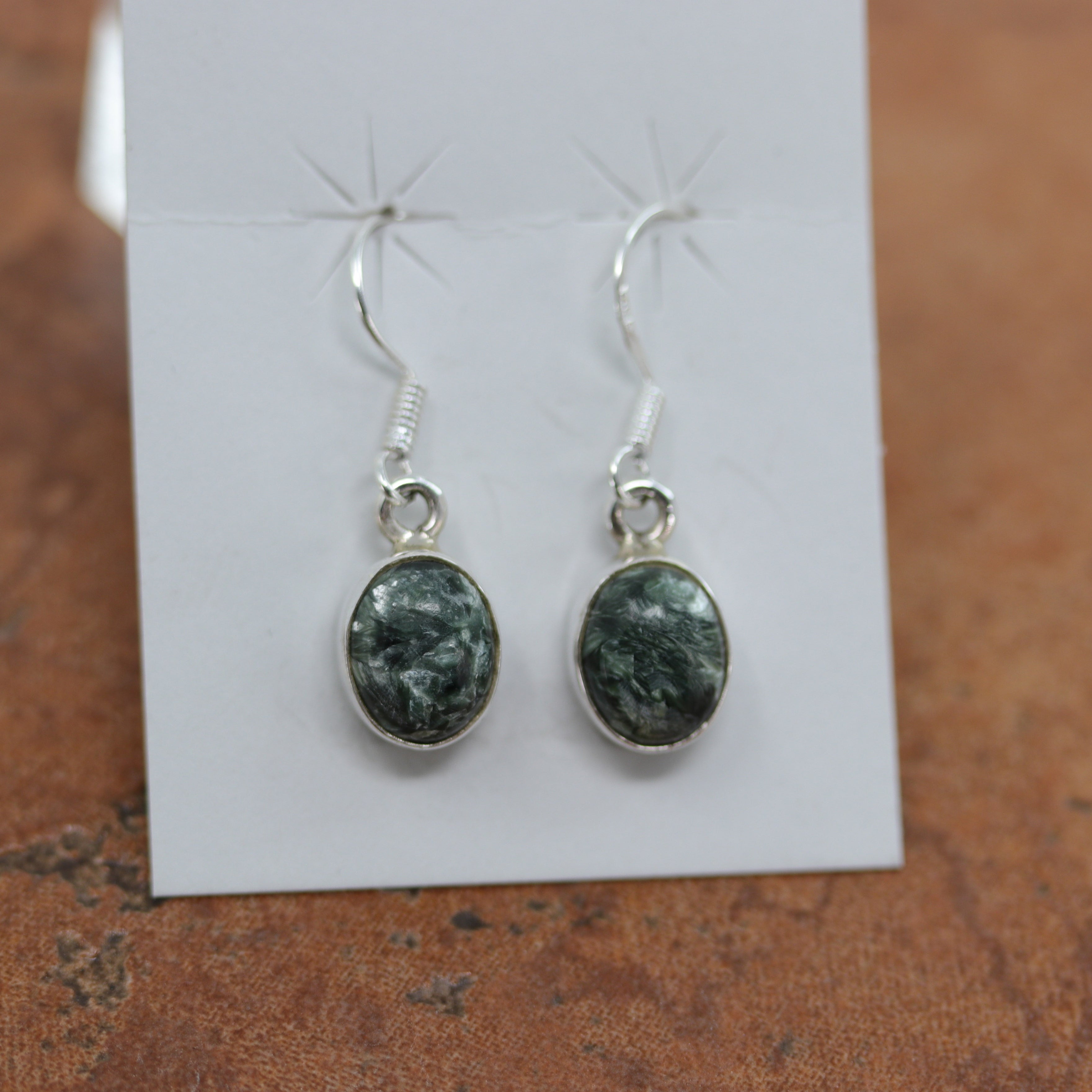Beautiful earrings made from sterling silver and green seraphinite. The earrings are about 1 1/4" in length including the hook and 1/2" in width.