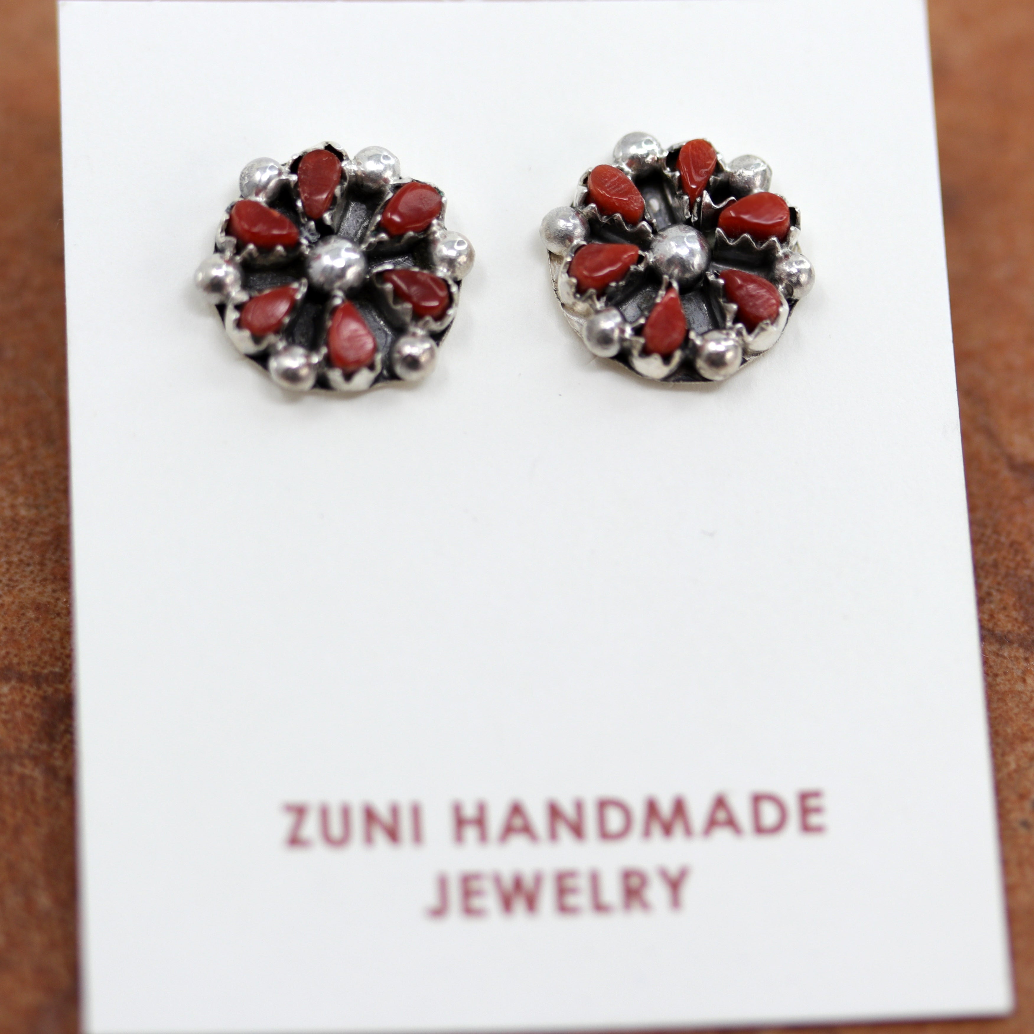 Zuni Native American stud earrings with a cluster design. They are made from sterling silver and coral. Each earring is 1/2" in length.