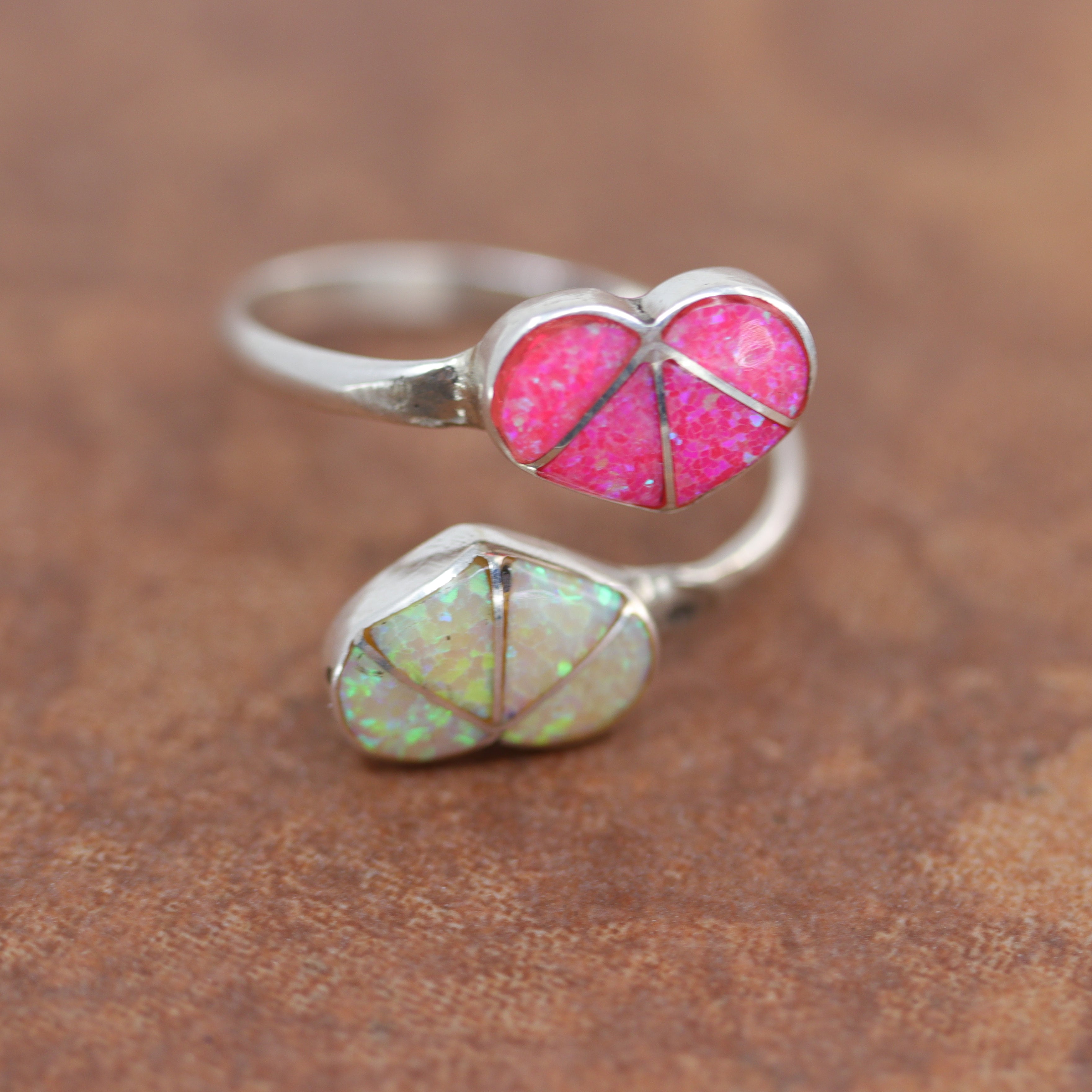 Adjustable silver ring with 2 heart shaped stones made of opal. One is pink the other white
