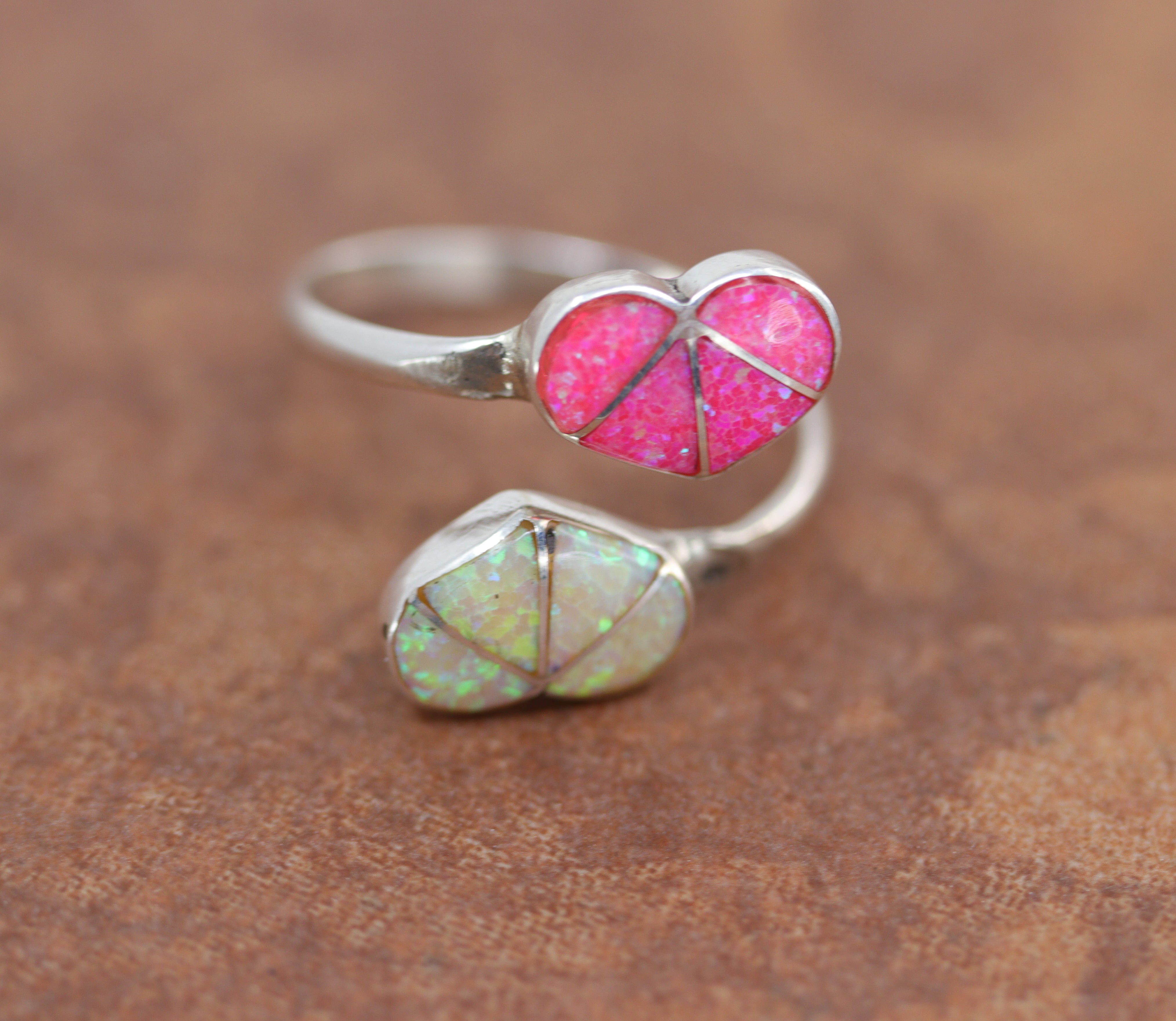 Adjustable silver ring with 2 heart shaped stones made of opal. One is pink the other white