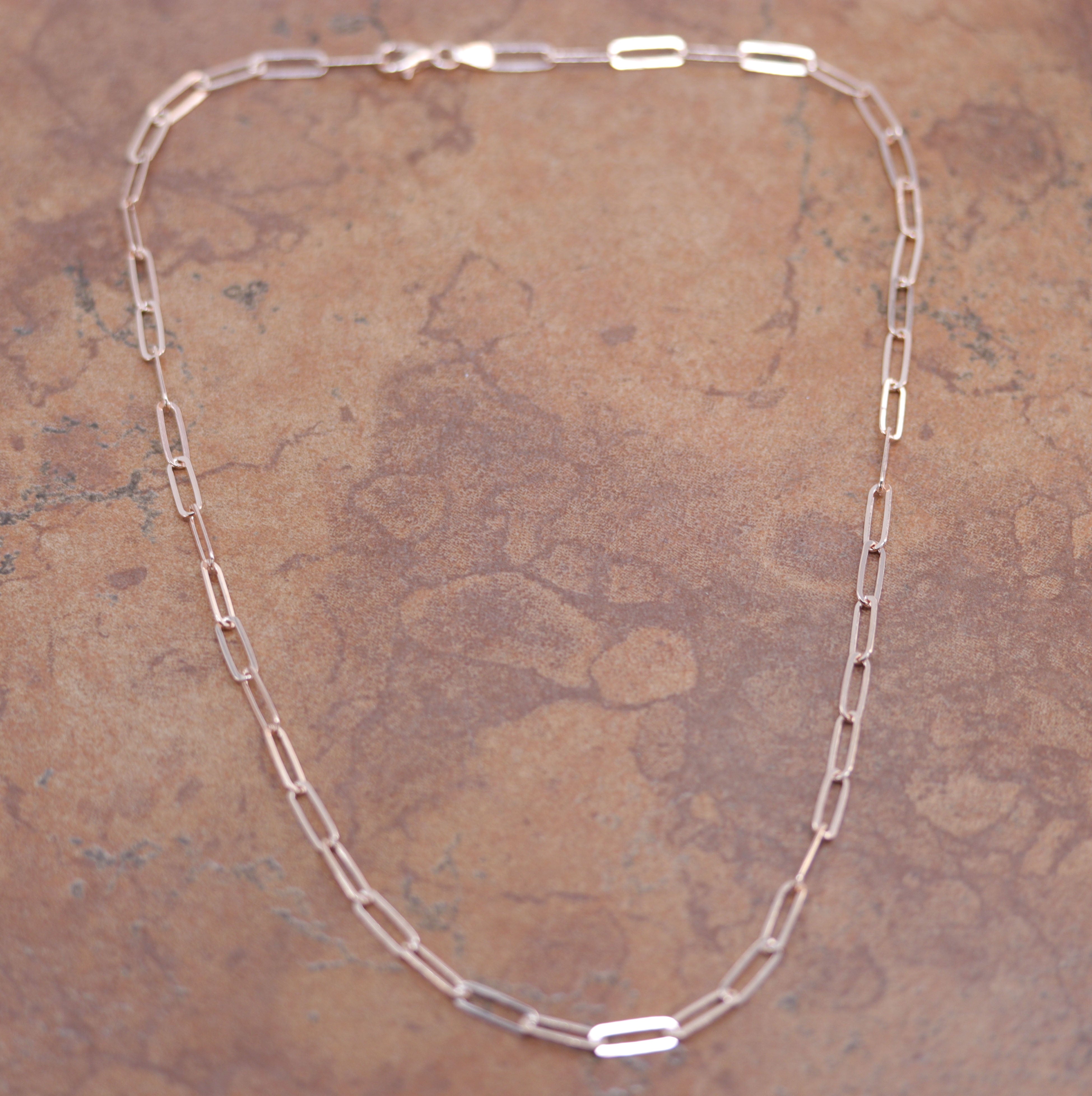 A Beautiful Paper Clip Chain Link Necklace. It is made from .925 sterling silver and rose gold overlay. The length is about 18" and the width is 3/16".